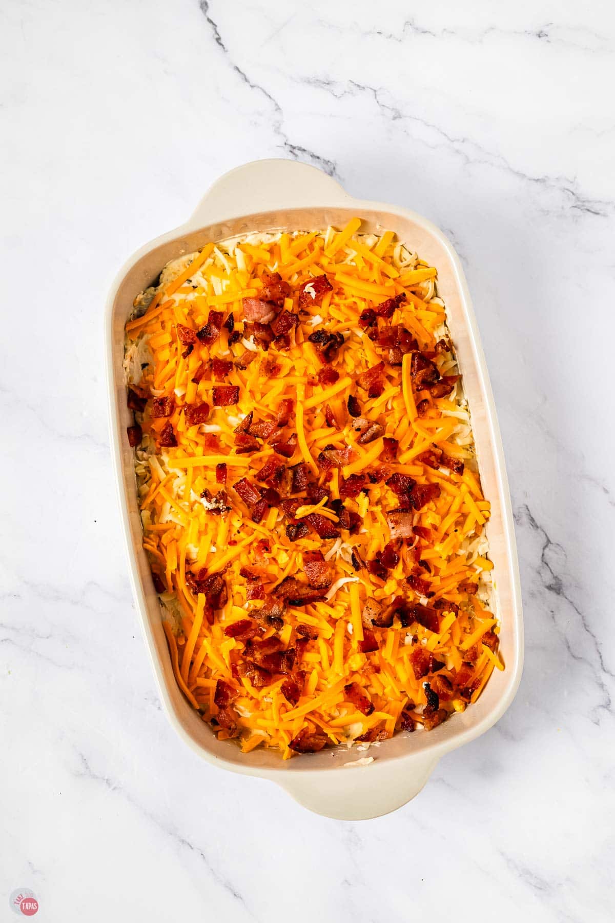 unbaked, cheesy dip in a white casserole dish