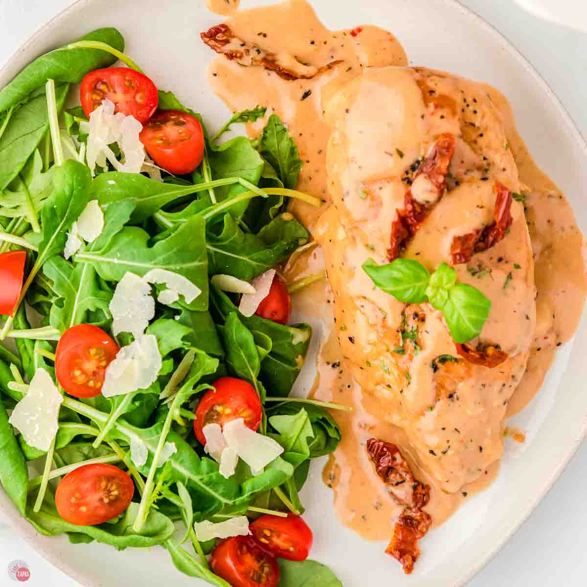chicken and a salad on a white plate