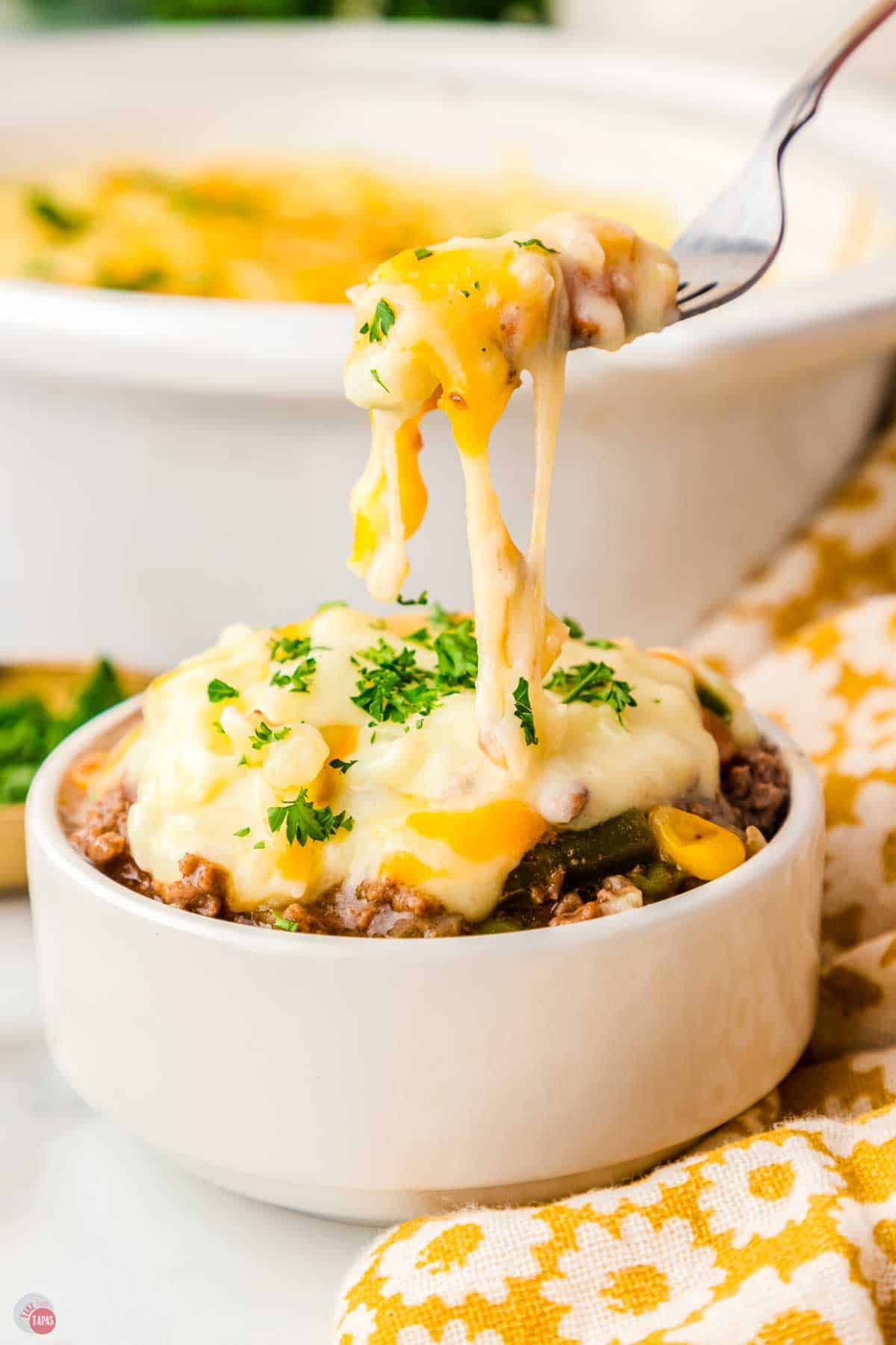 bowl of shepherd's pie with a fork taking a bite