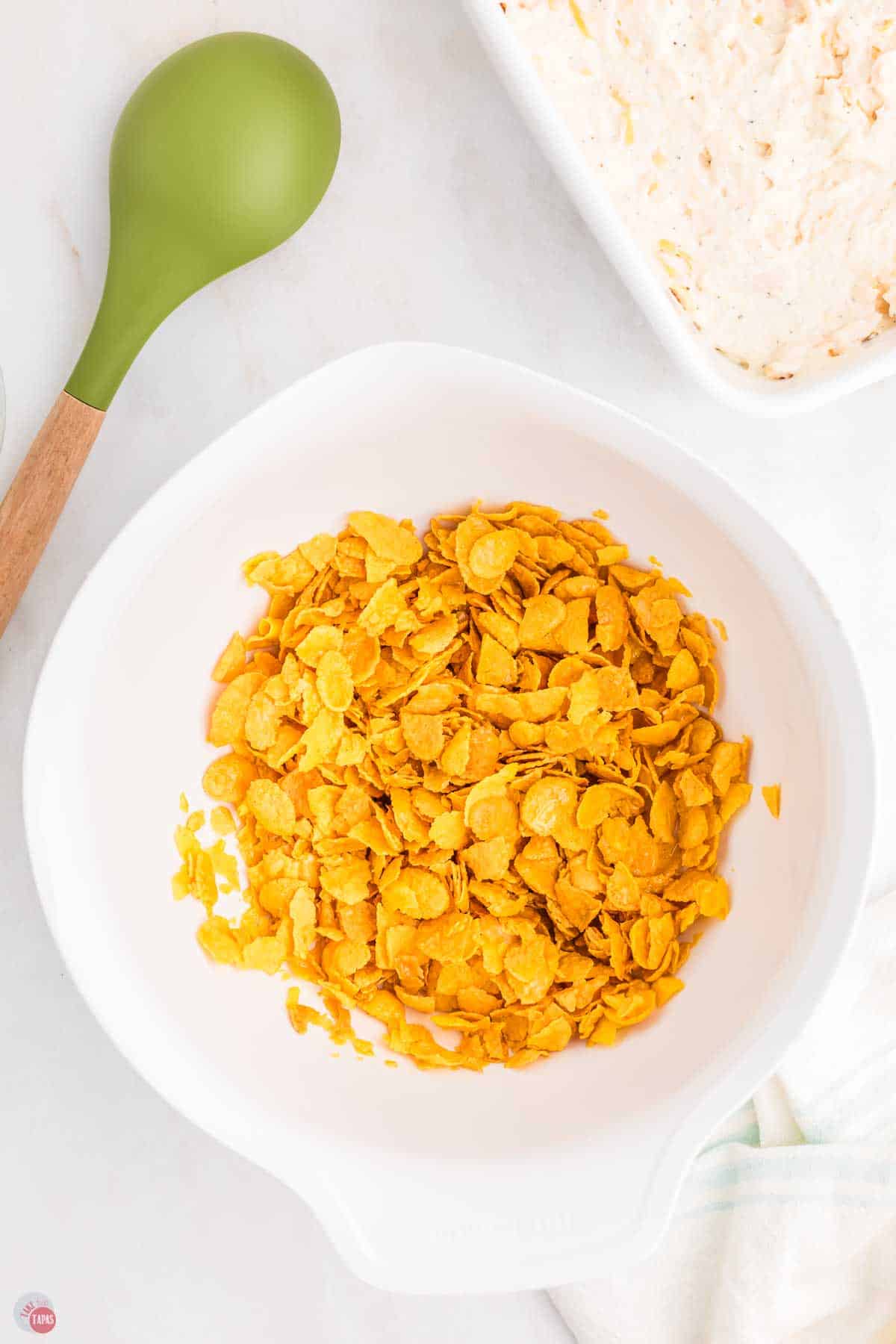 corn flakes and melted butter in a white bowl