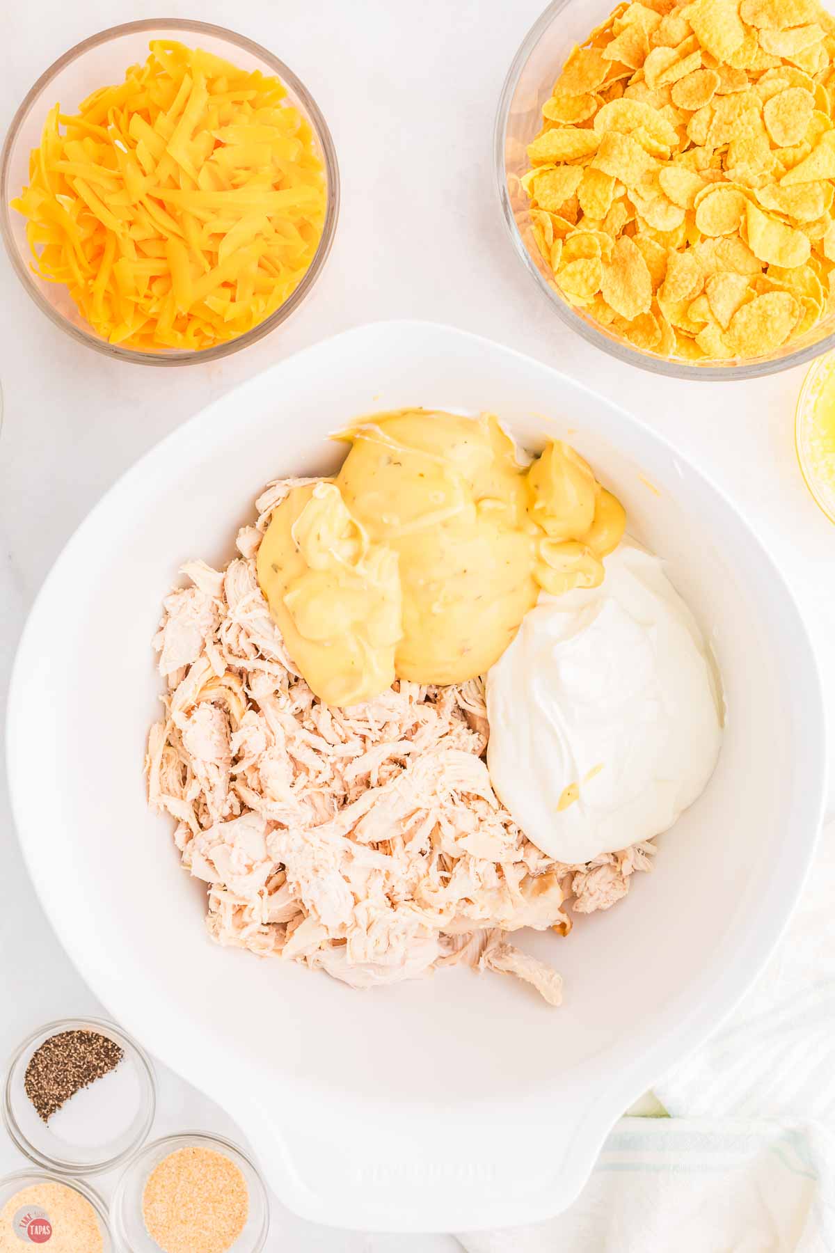 chicken, sour cream, and condensed soup unmixed in a white bowl