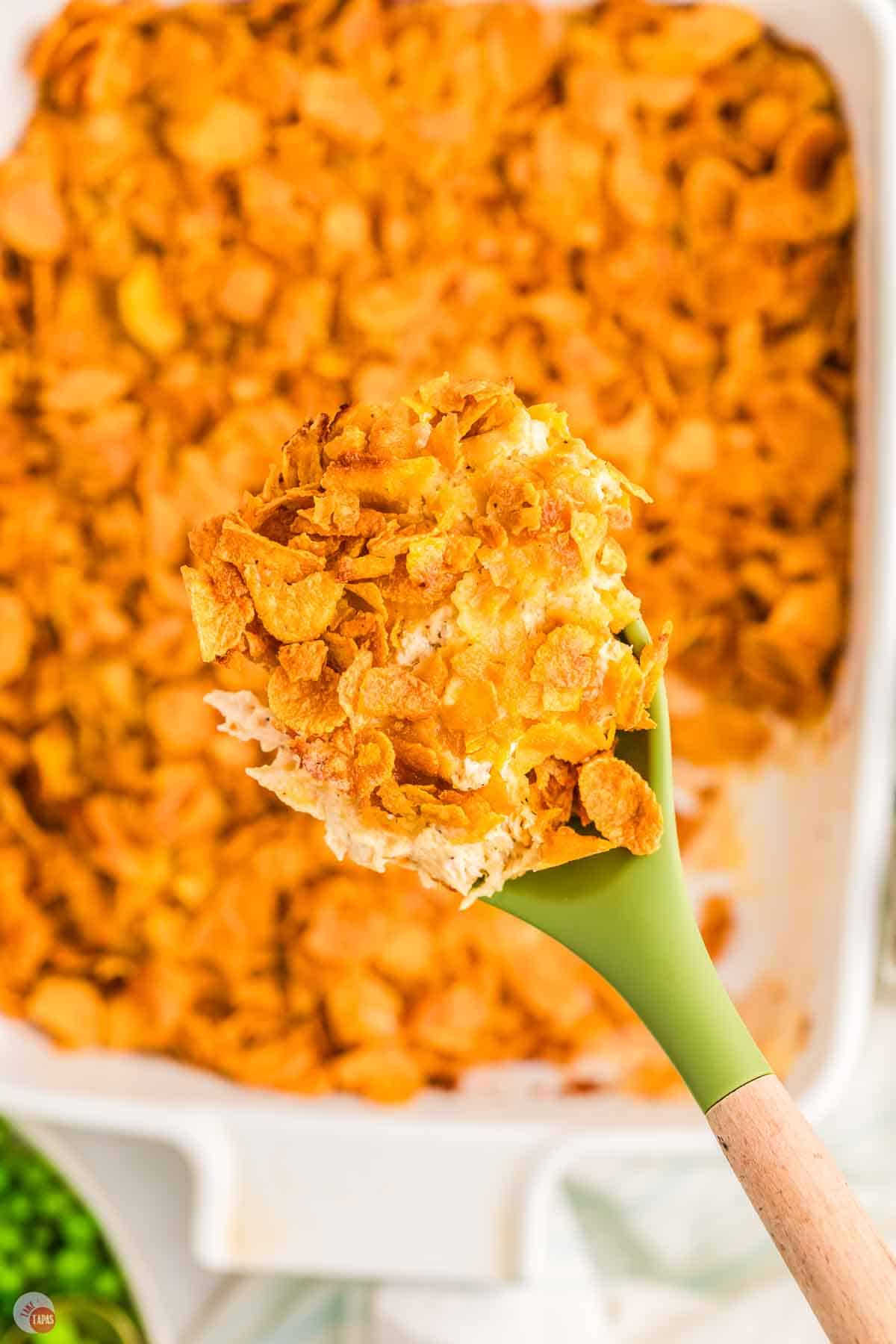 close up of green spatula with a scoop of chicken casserole
