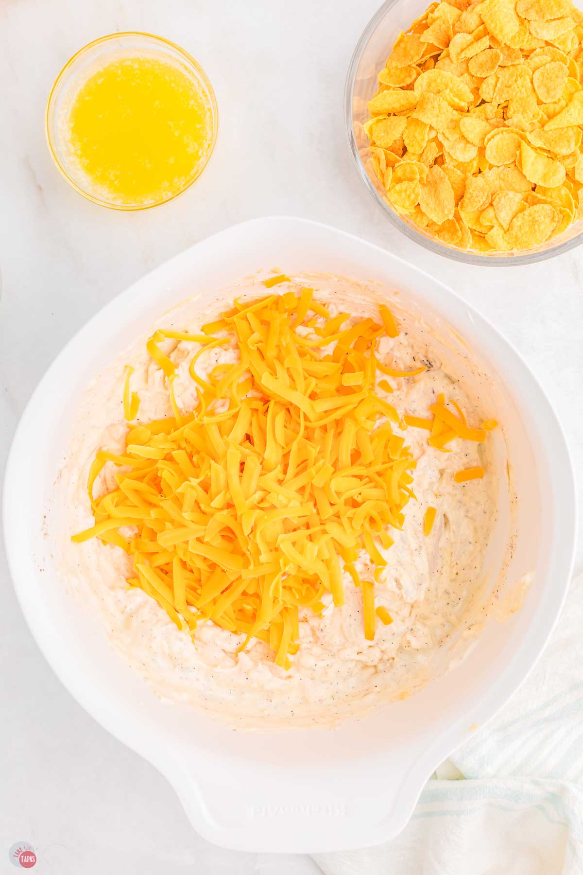 bowl of chicken casserole mixture topped with shredded cheese