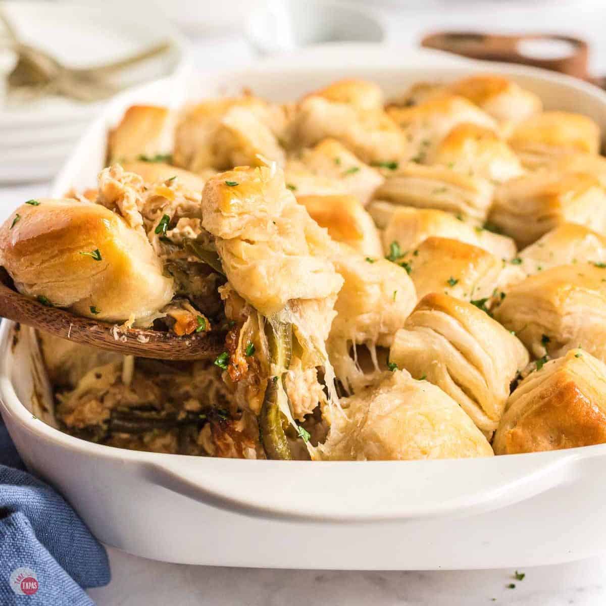 white dish with chicken casserole being scooped out of it