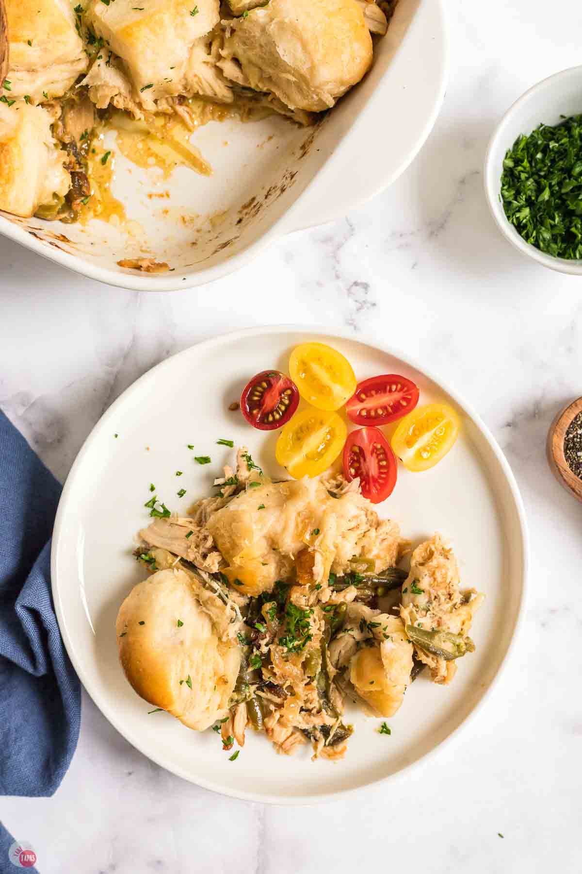 plate of chicken with cherry tomatoes and biscuits