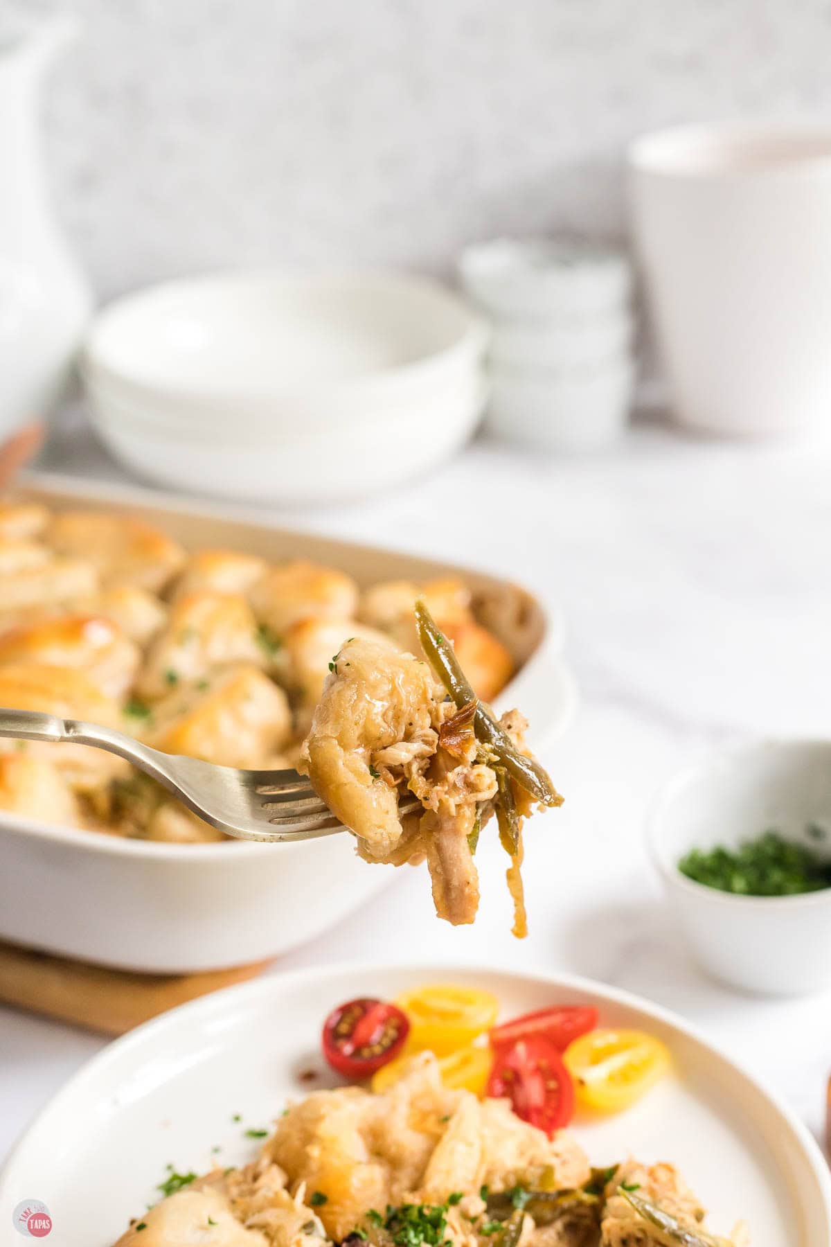 fork with a piece of chicken and green beans on it