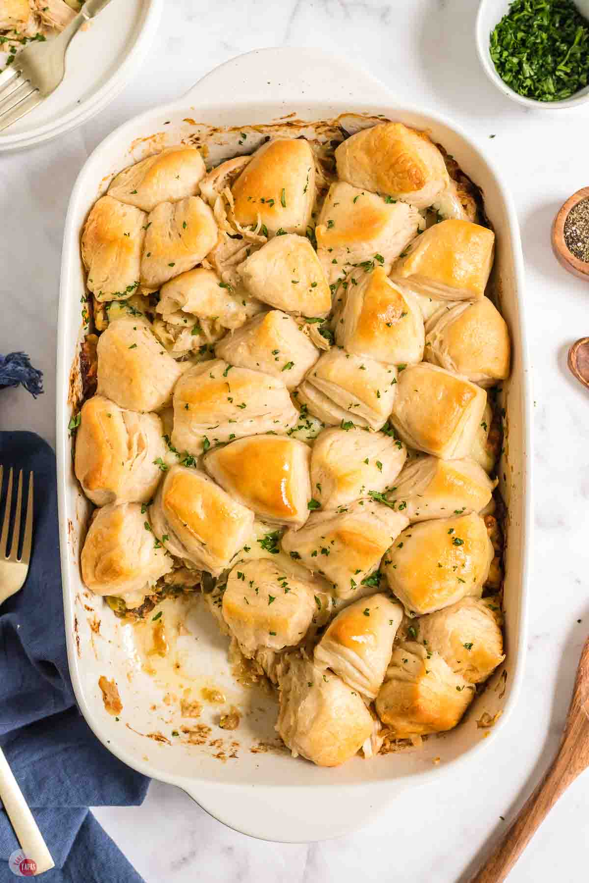 casserole with biscuits on top and a scoop missing
