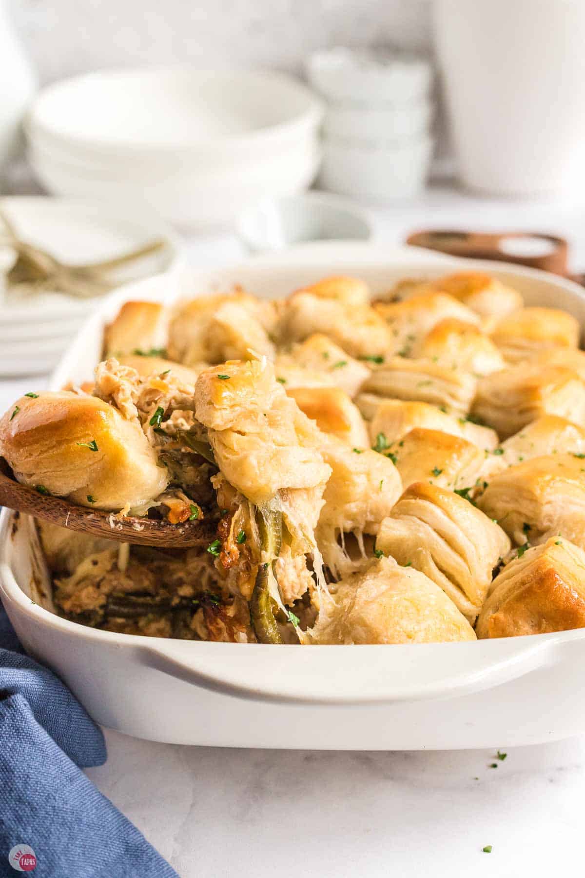 white dish with chicken casserole being scooped out of it