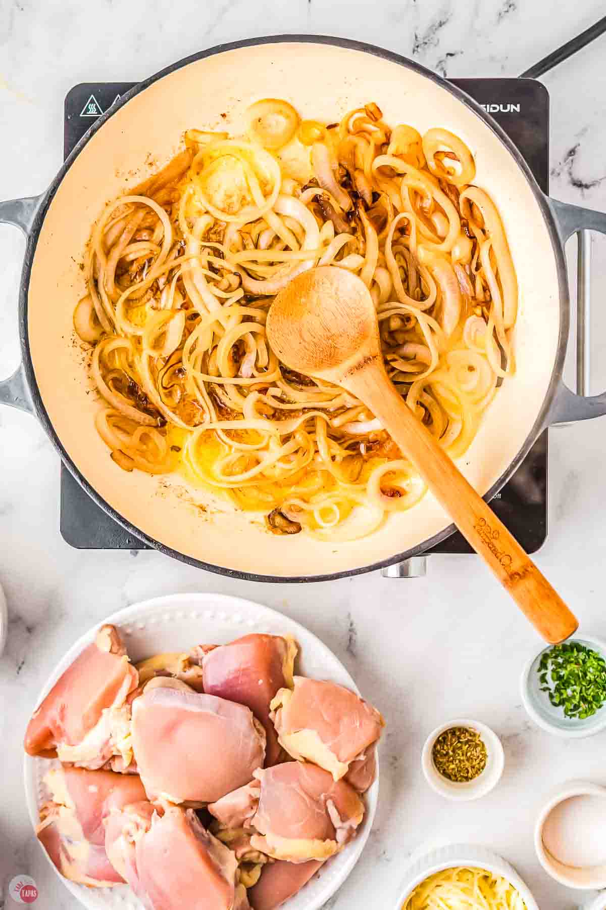 white pan with onions caramelizing in it