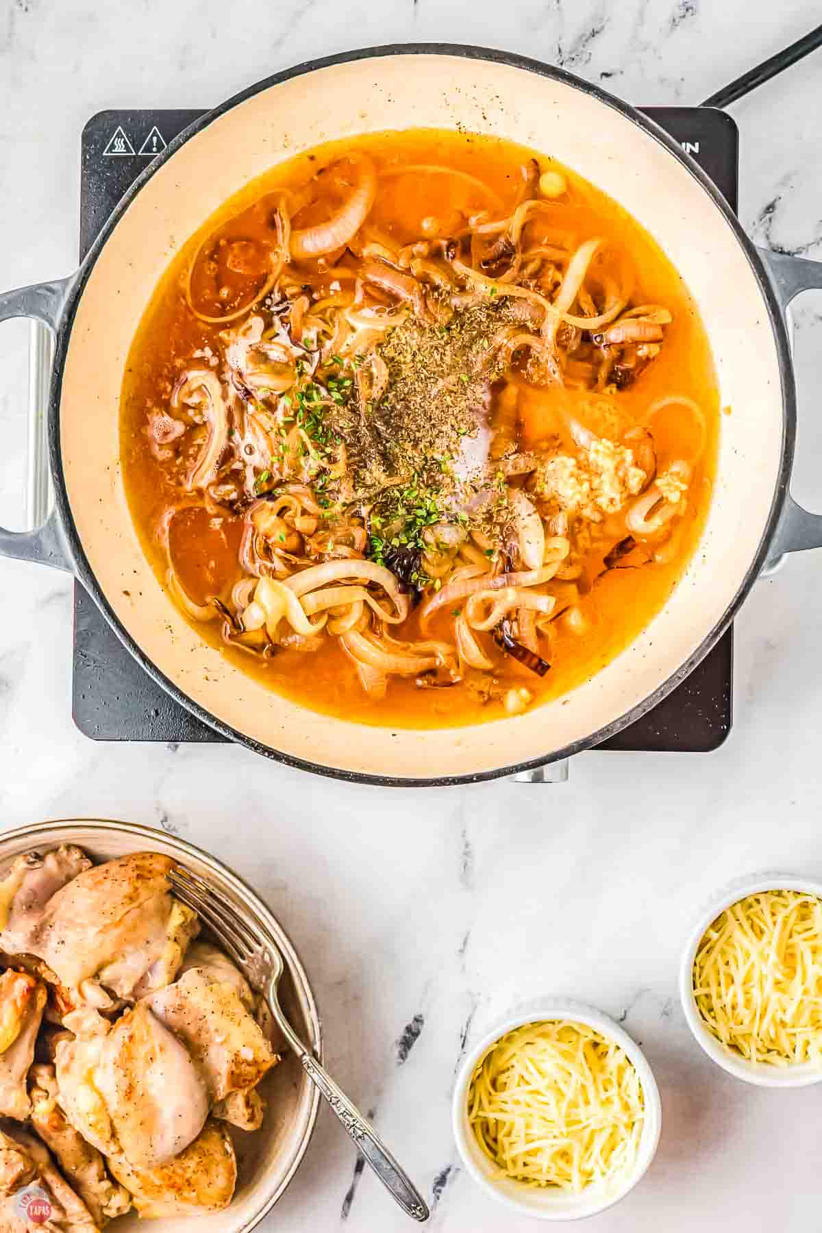 skillet with onions, spices, and broth cooking