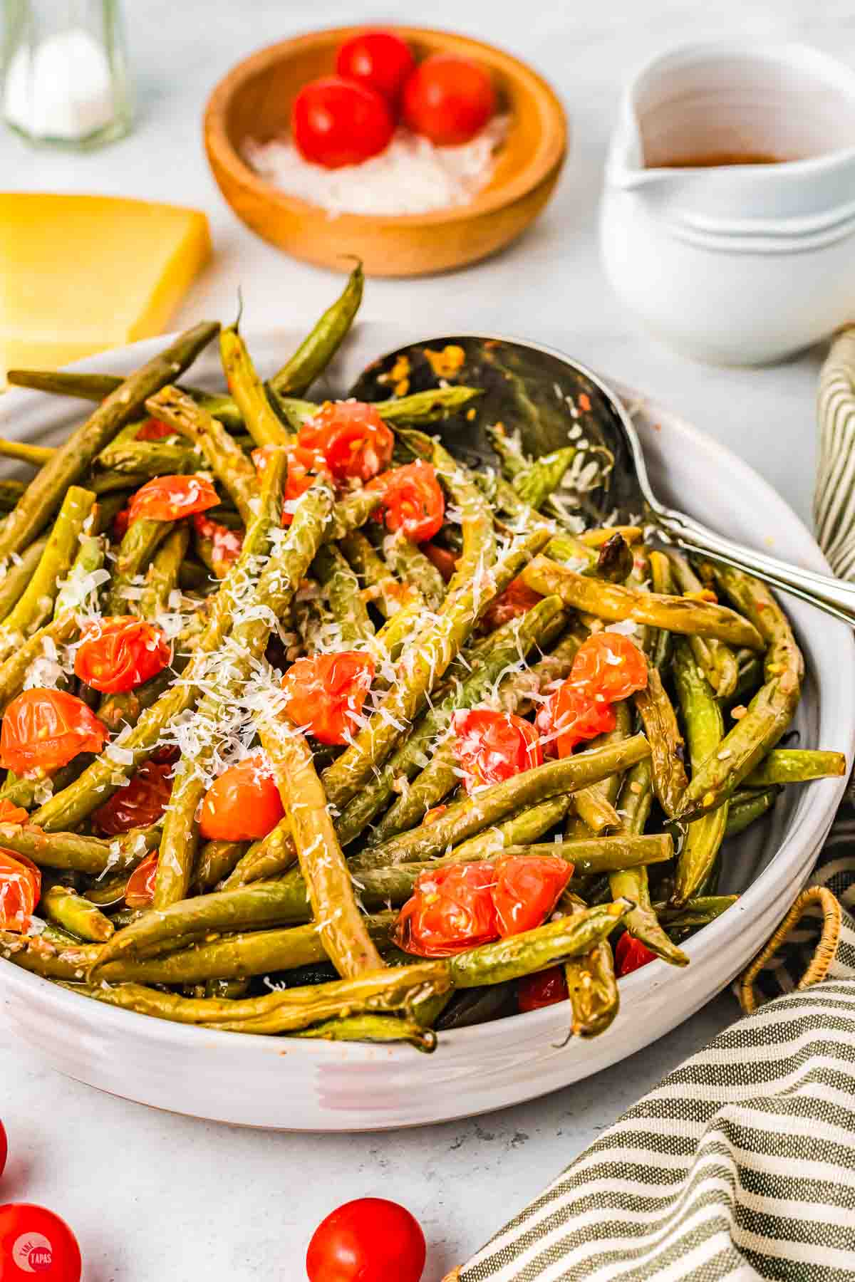 side view of bowl of Italian green beans with a silver spoon in them