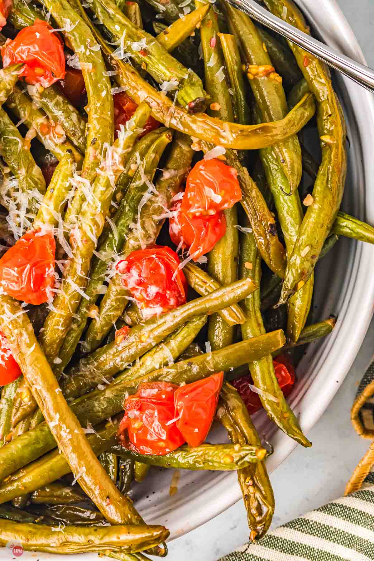 close up of green beans with shredded cheese on top