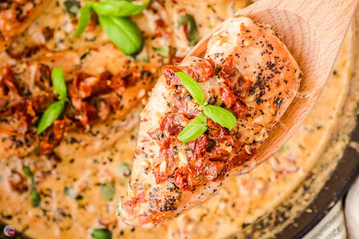 wood spoon holding a piece of chicken