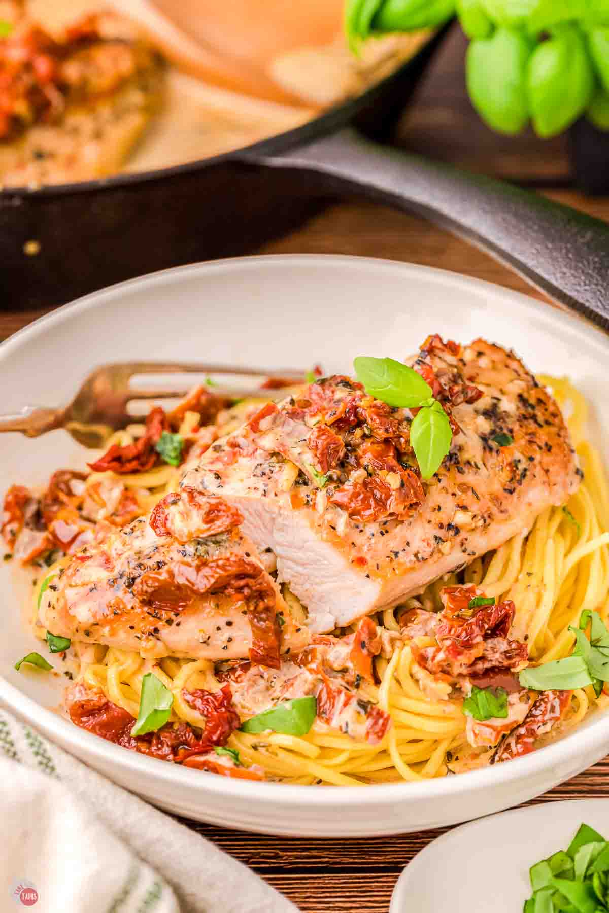 white bowl of marry me chicken over pasta