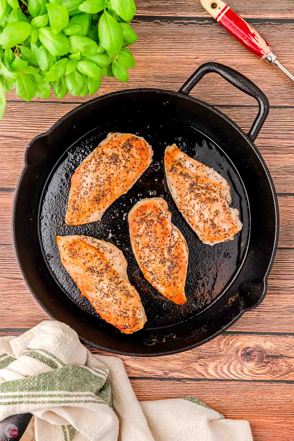 black skillet with 4 cooked chicken breasts