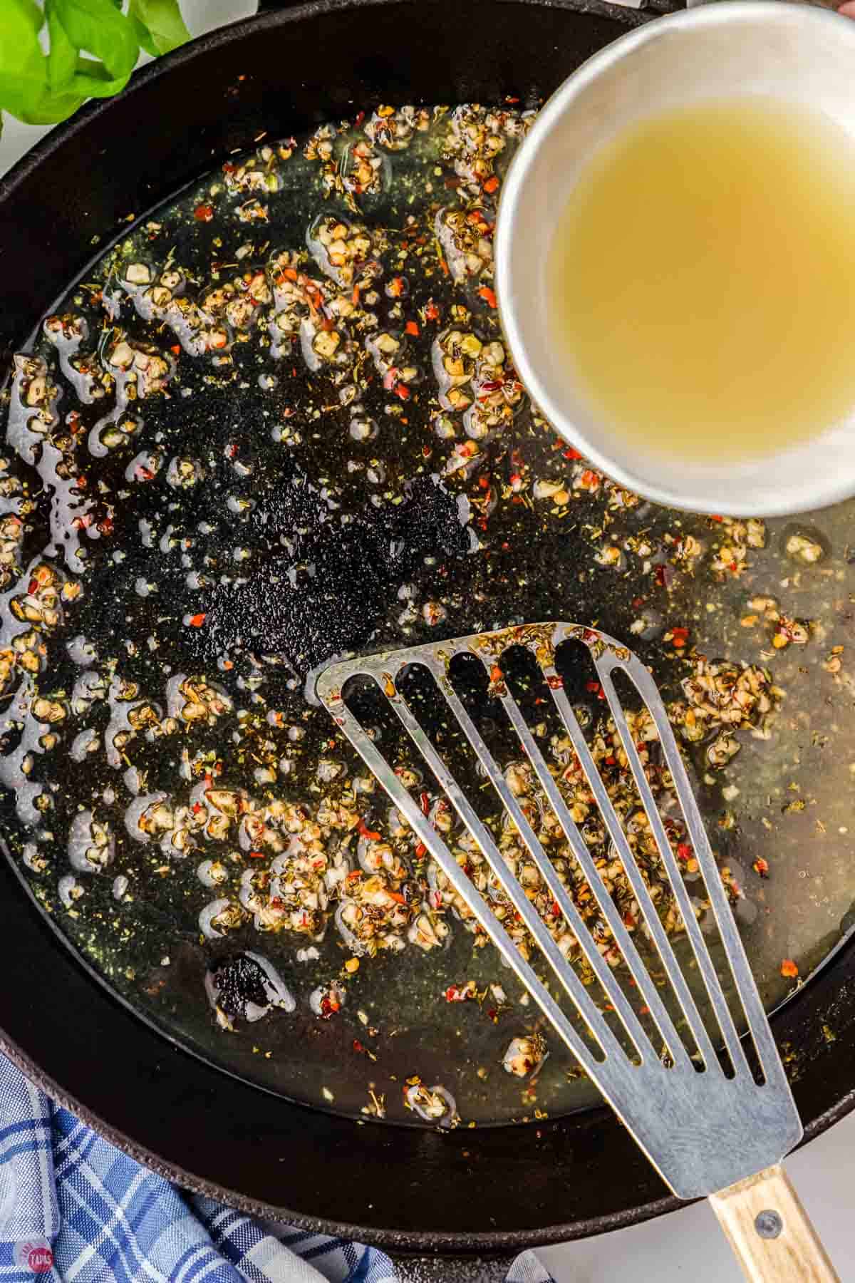 garlic, onion, and broth simmering in a pan