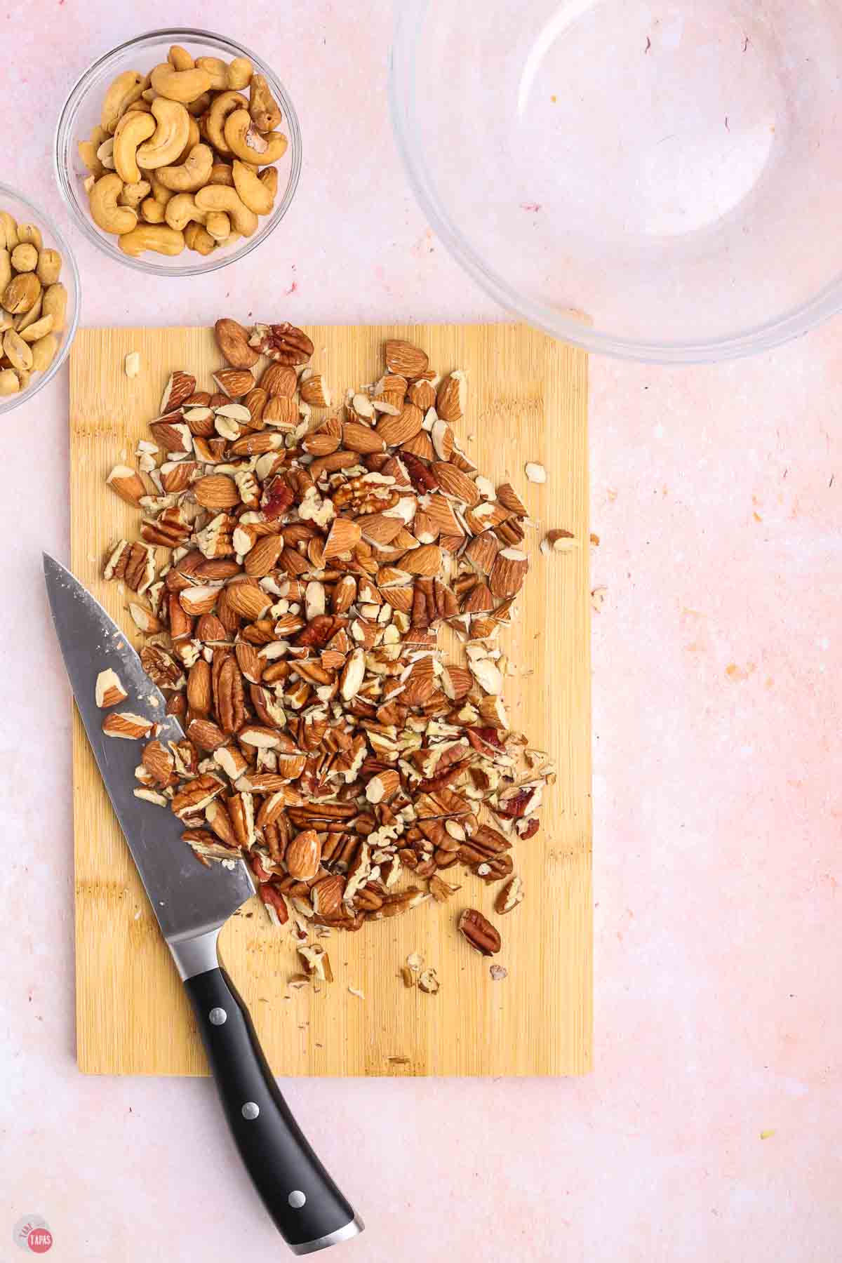 cutting board with a knife and chopped nut on it