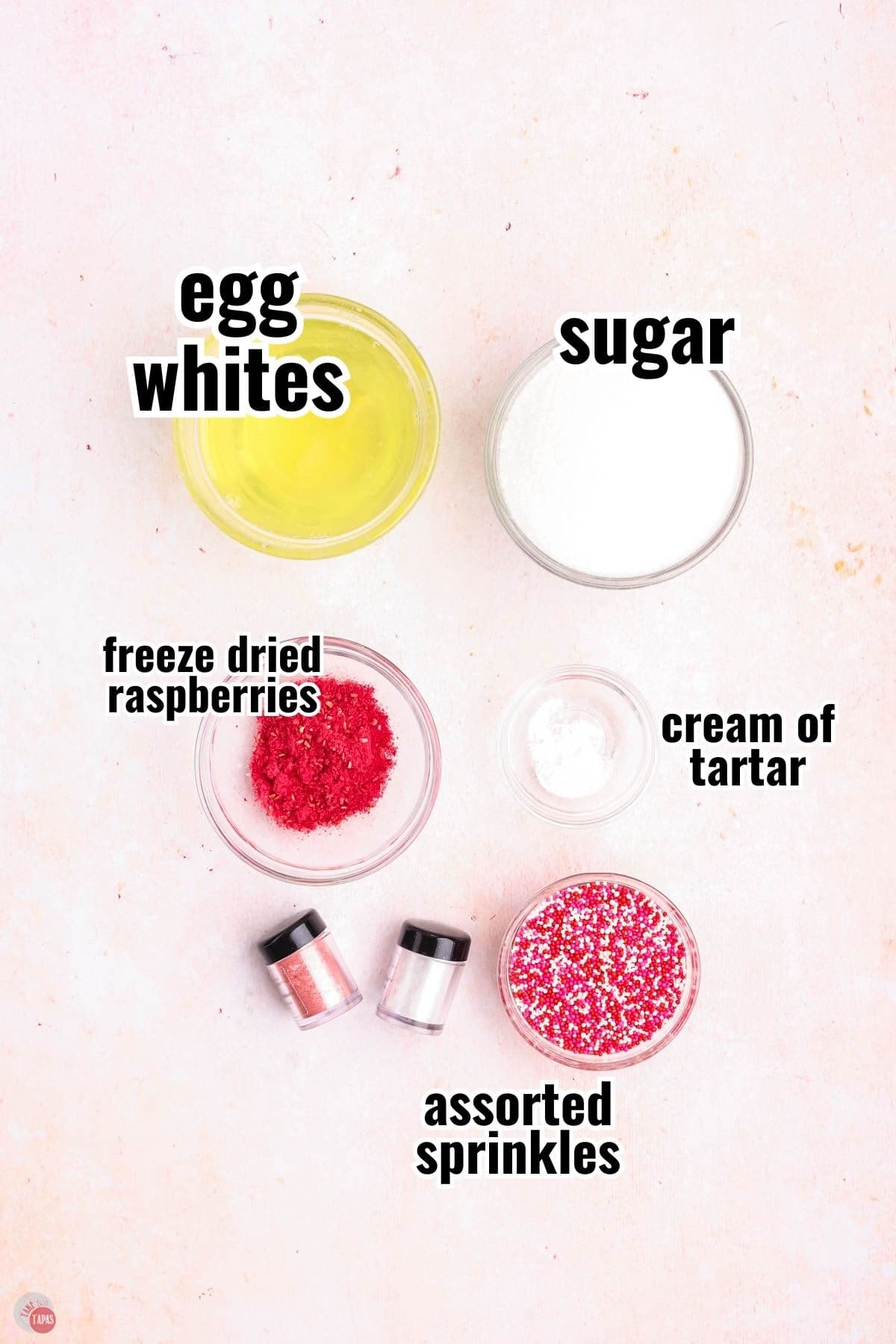 ingredients for a meringue cookie recipe in individual bowls with text overlay labeling them