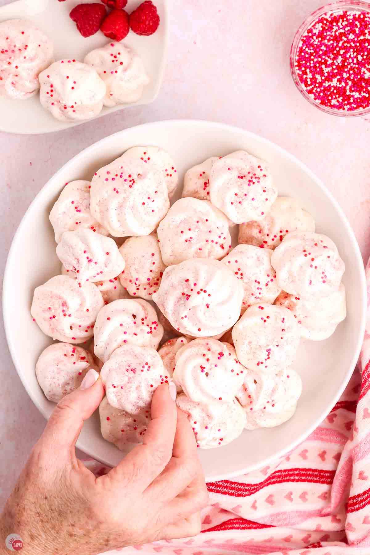 hand picking up a meringue cookie