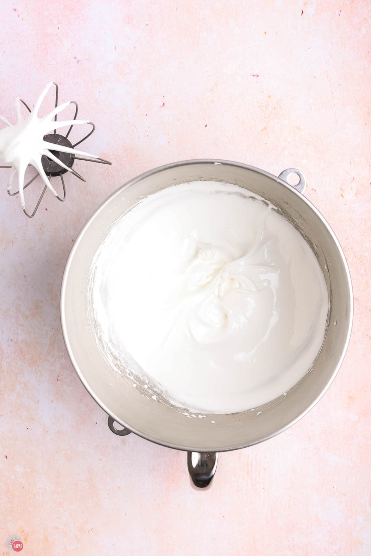 whipped meringue in a silver mixing bowl