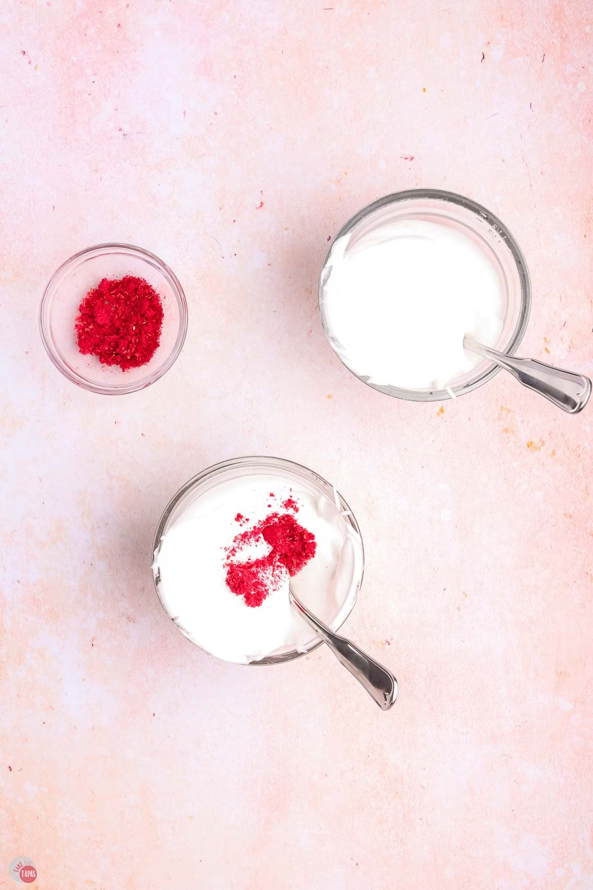 two small bowls of white meringue and a small bowl of red powder