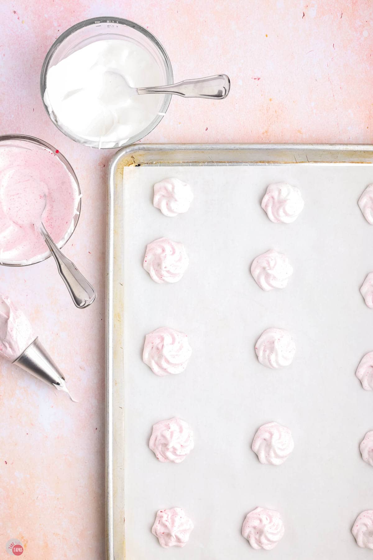 parchment lined baking sheet with meringue piped into small star shapes