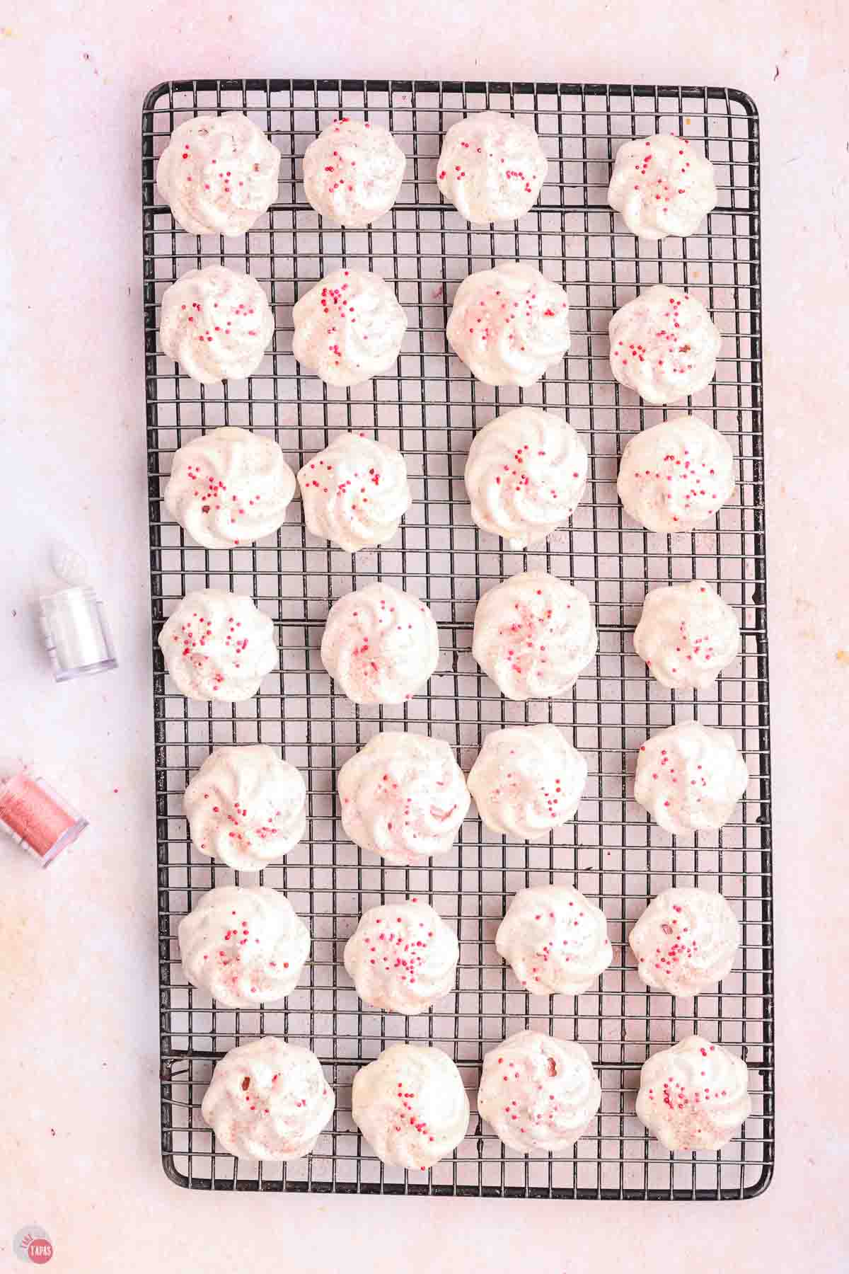 raspberry meringue cookies on a black, wire cooling rack