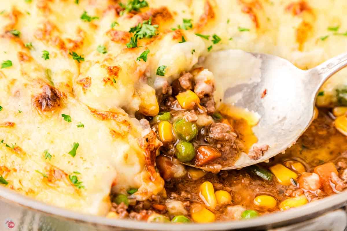 close up of a spoon scooping meat and vegetables
