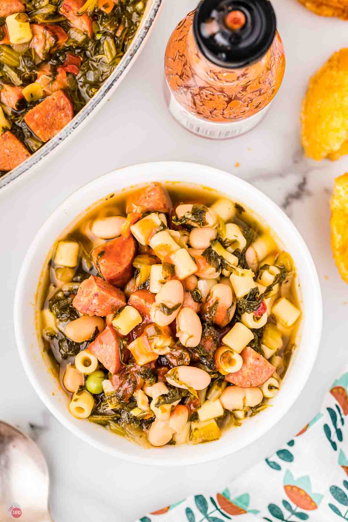 bowl of swamp soup next to a jar of hot sauce