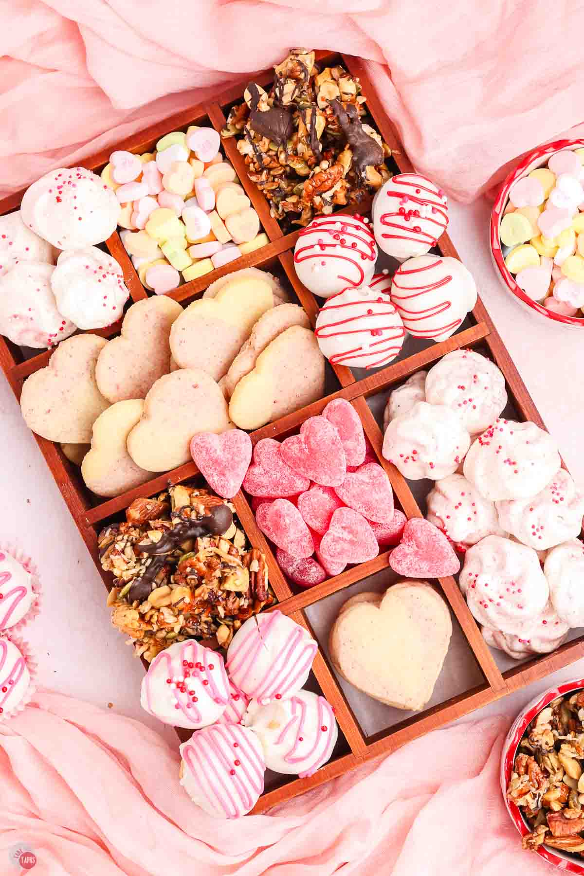 wood box with pink and white treats in it