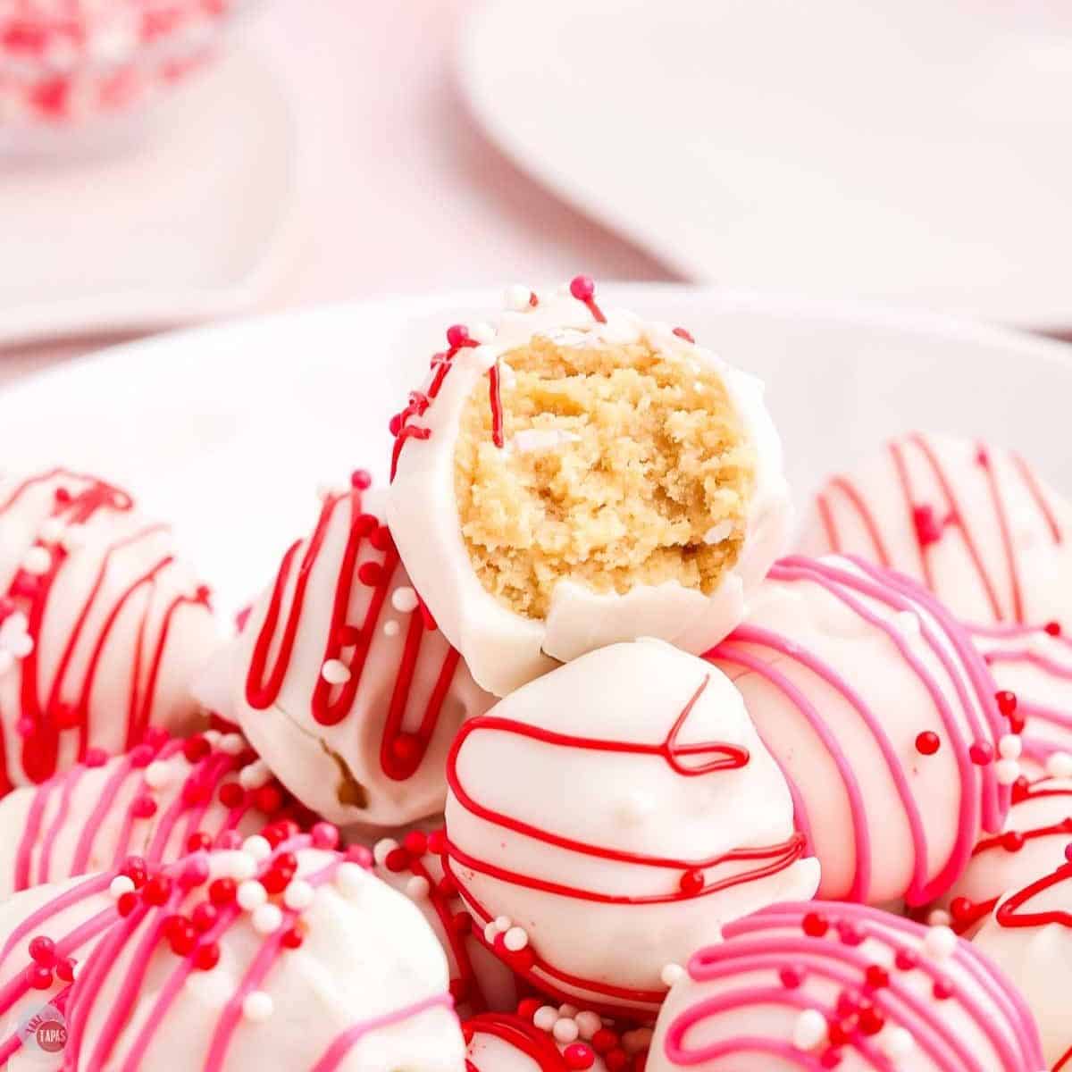 Golden Oreo cake balls with red and pink stripes and sprinkles.