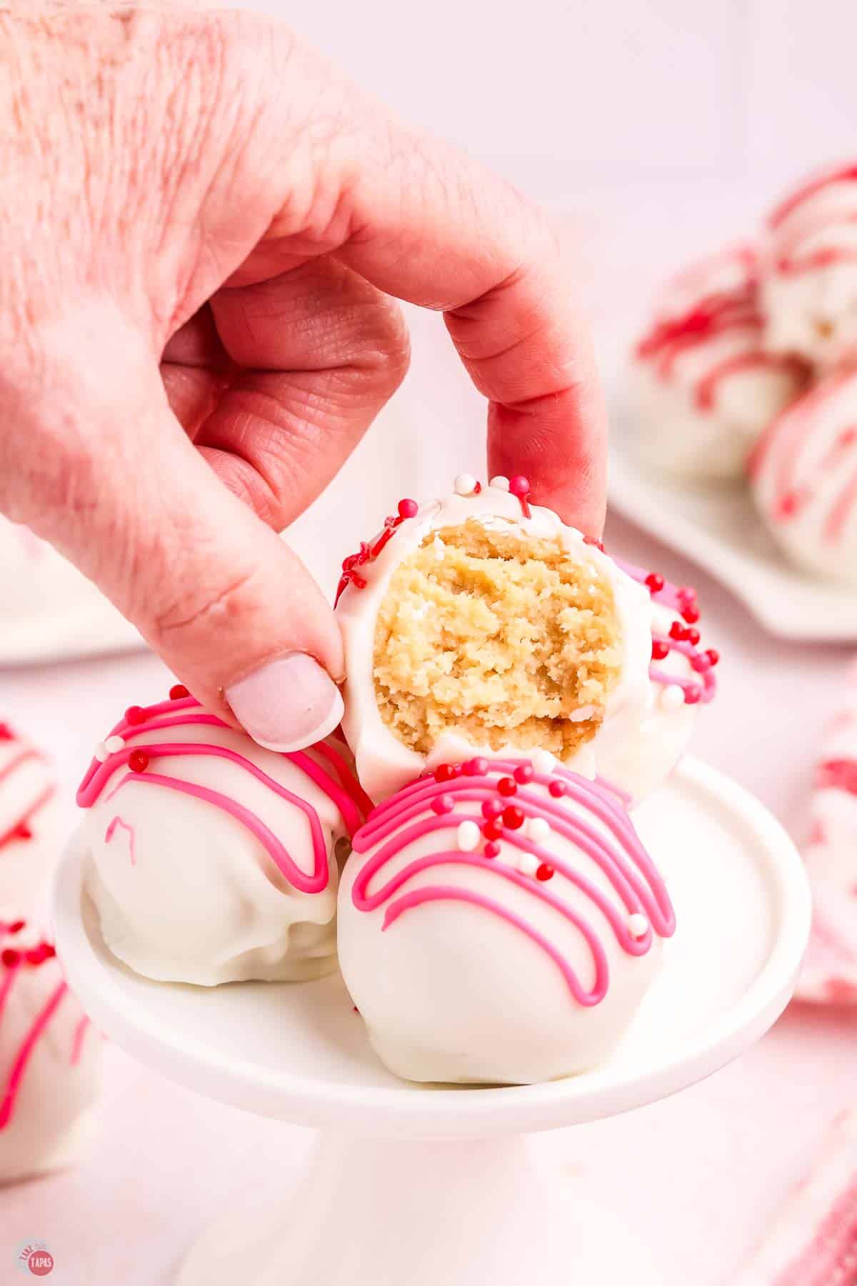 hand picking up a truffle from a white plate