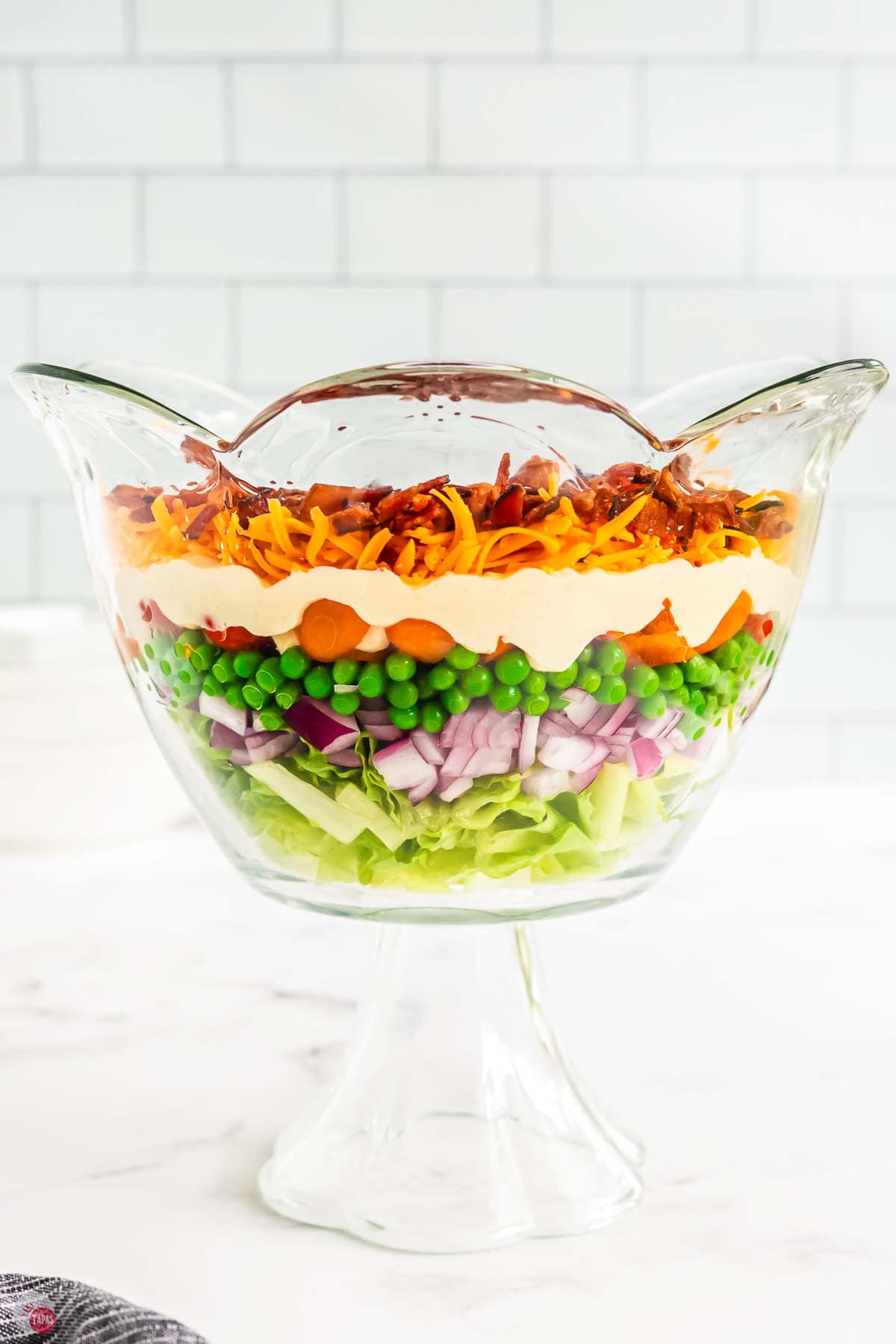 layered salad topped with cheese and bacon