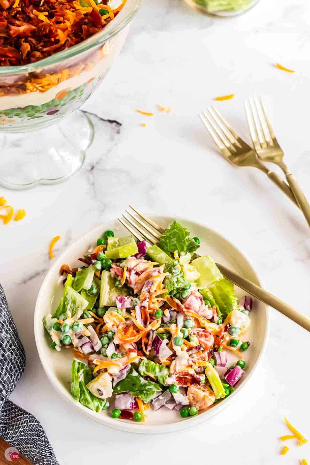 bowl bowl with salad and a stack of forks