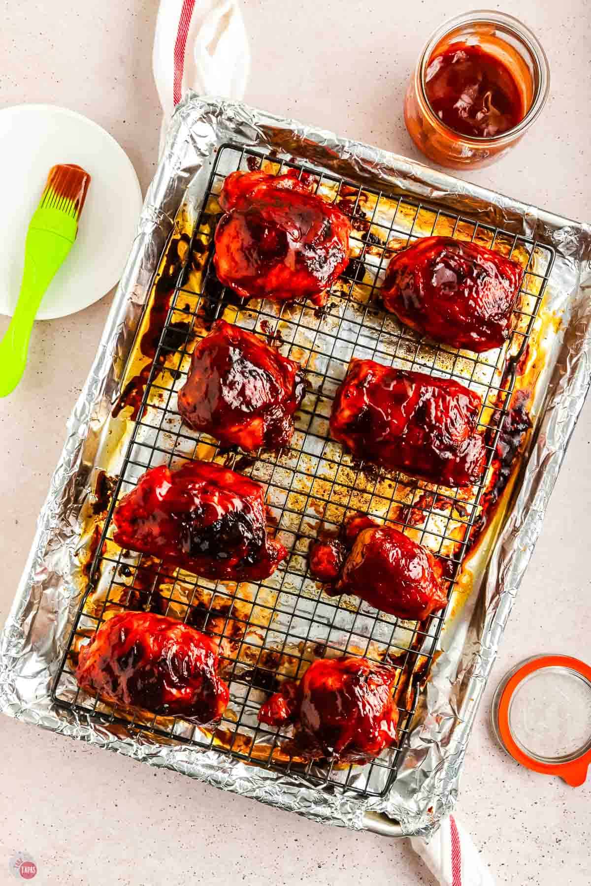 baked bbq chicken on a baking sheet with a wire rack