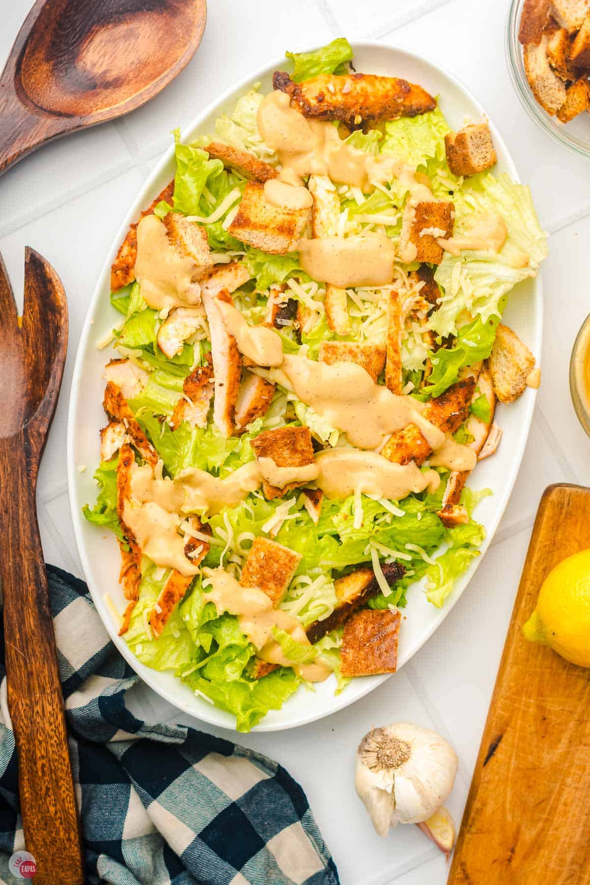 white platter with a blackened chicken caesar salad on it