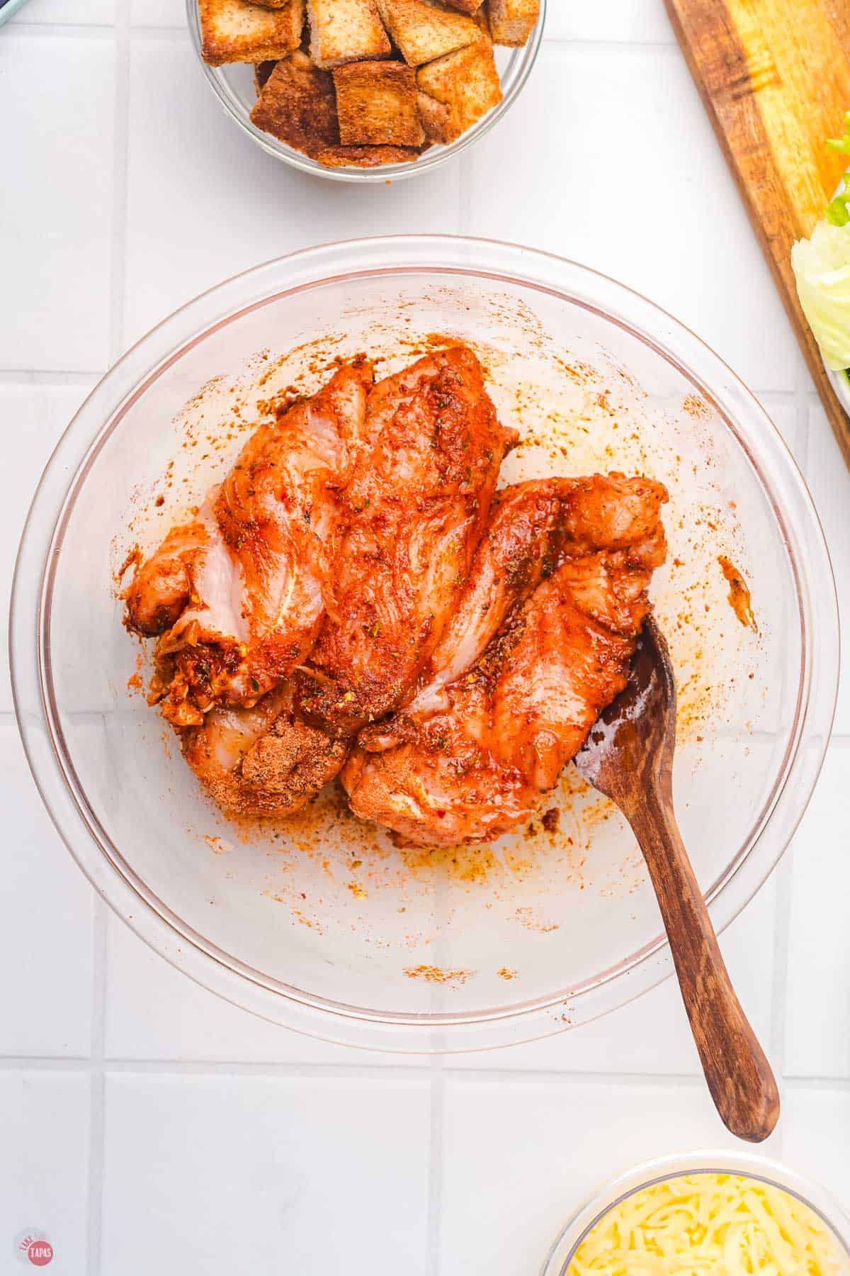 chicken breasts in a bowl with blackening seasoning on them