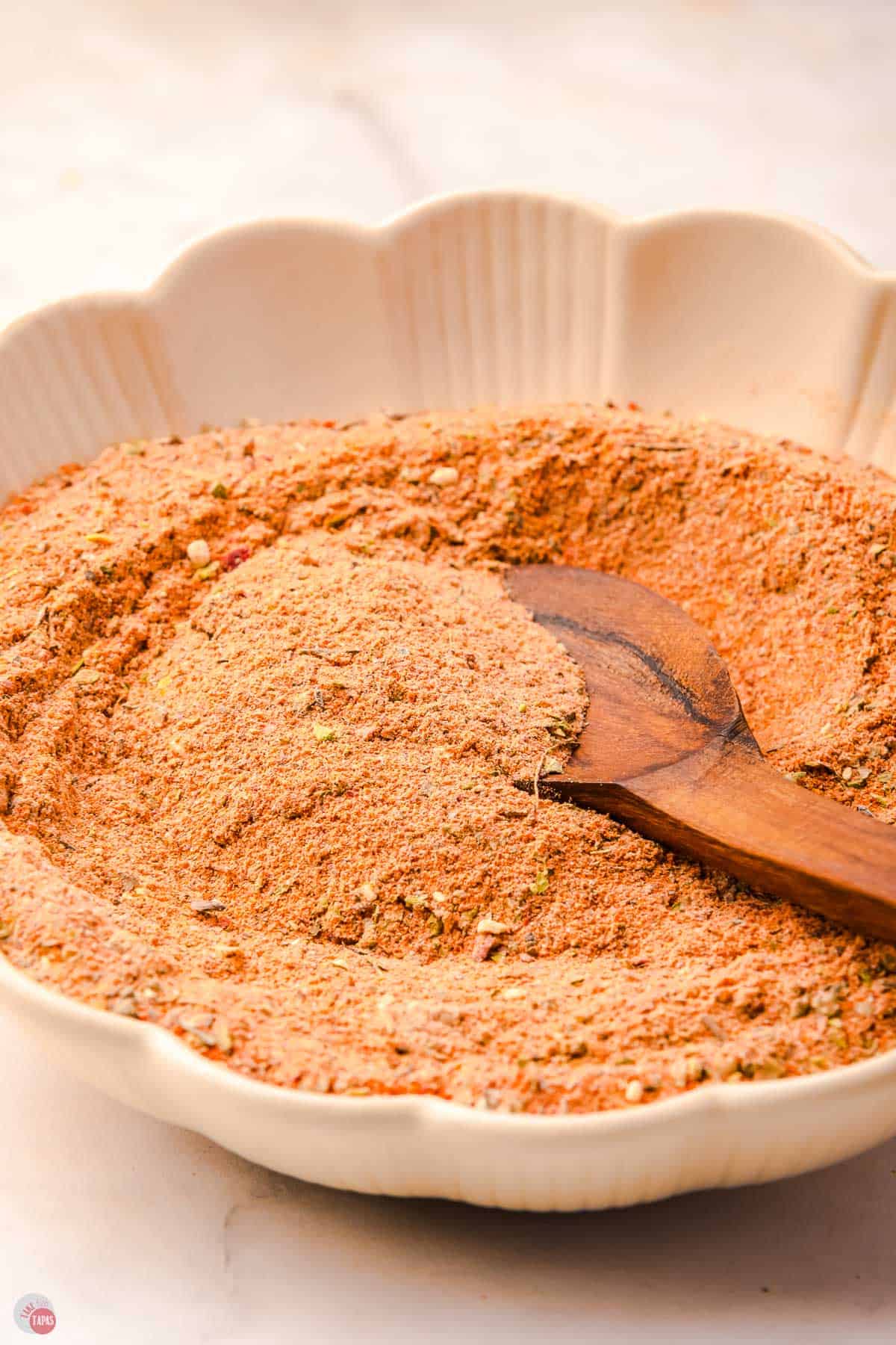 bowl of blackening seasoning with a wood spoon