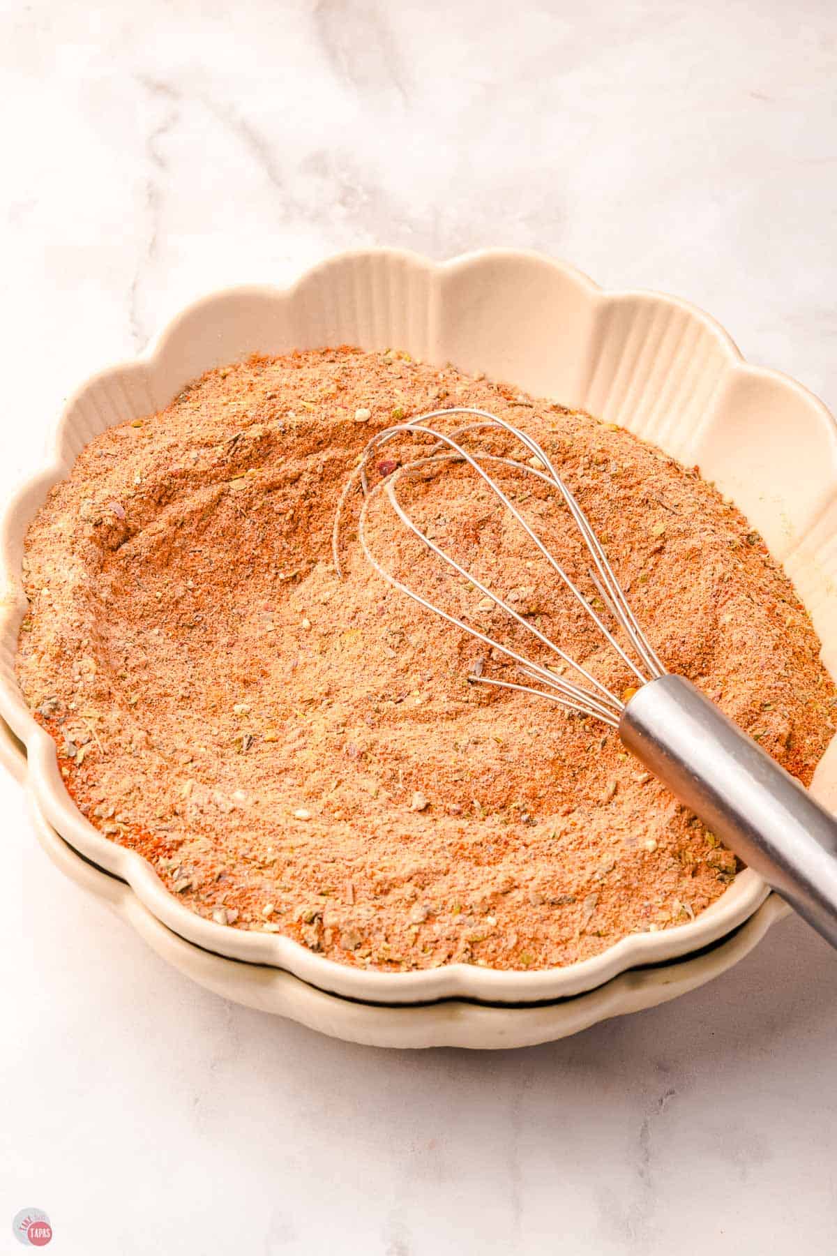 scalloped bowl of blackening seasoning with a swhisk