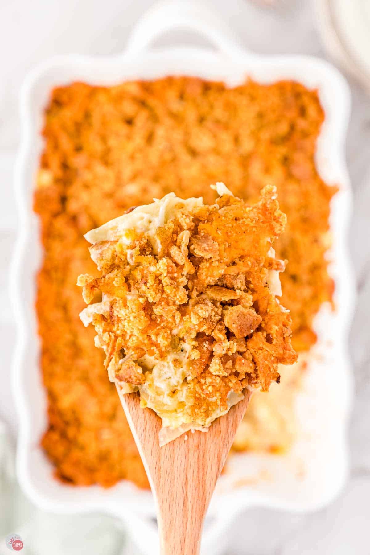 close of up wood spatula with a scoop of casserole on it