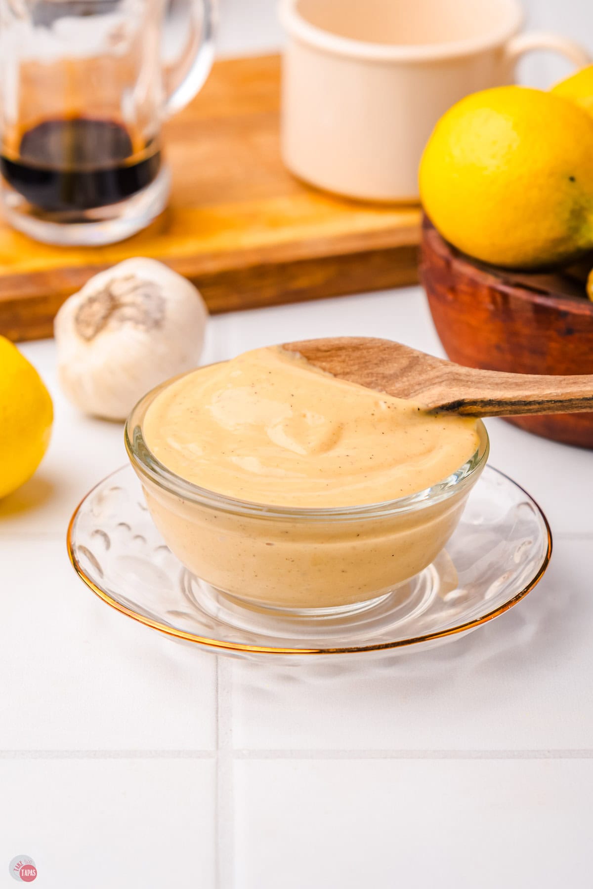 clear bowl of caesar salad dressing on a clear saucer