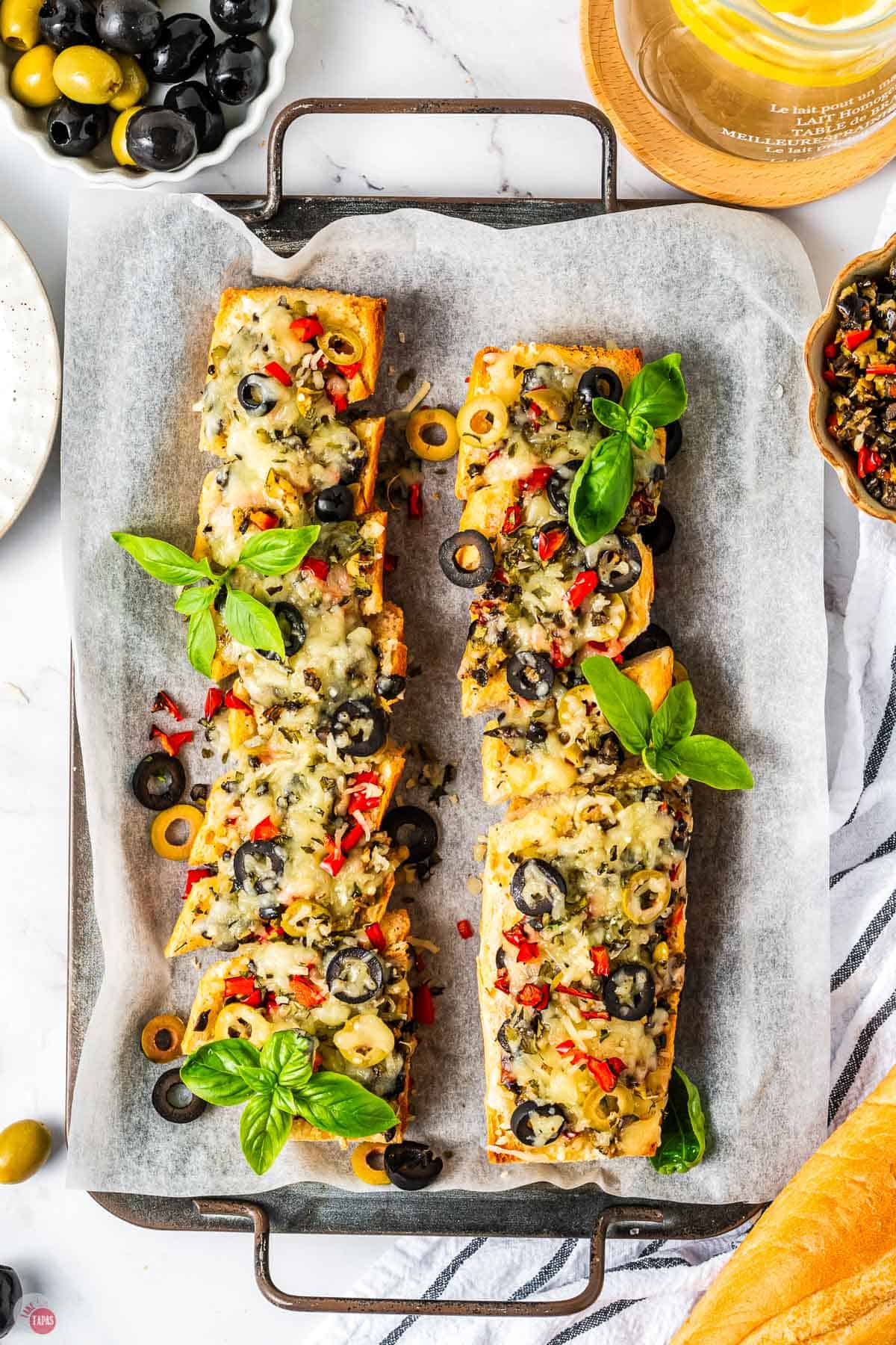 slices of olive bread on a pieces of parchment paper