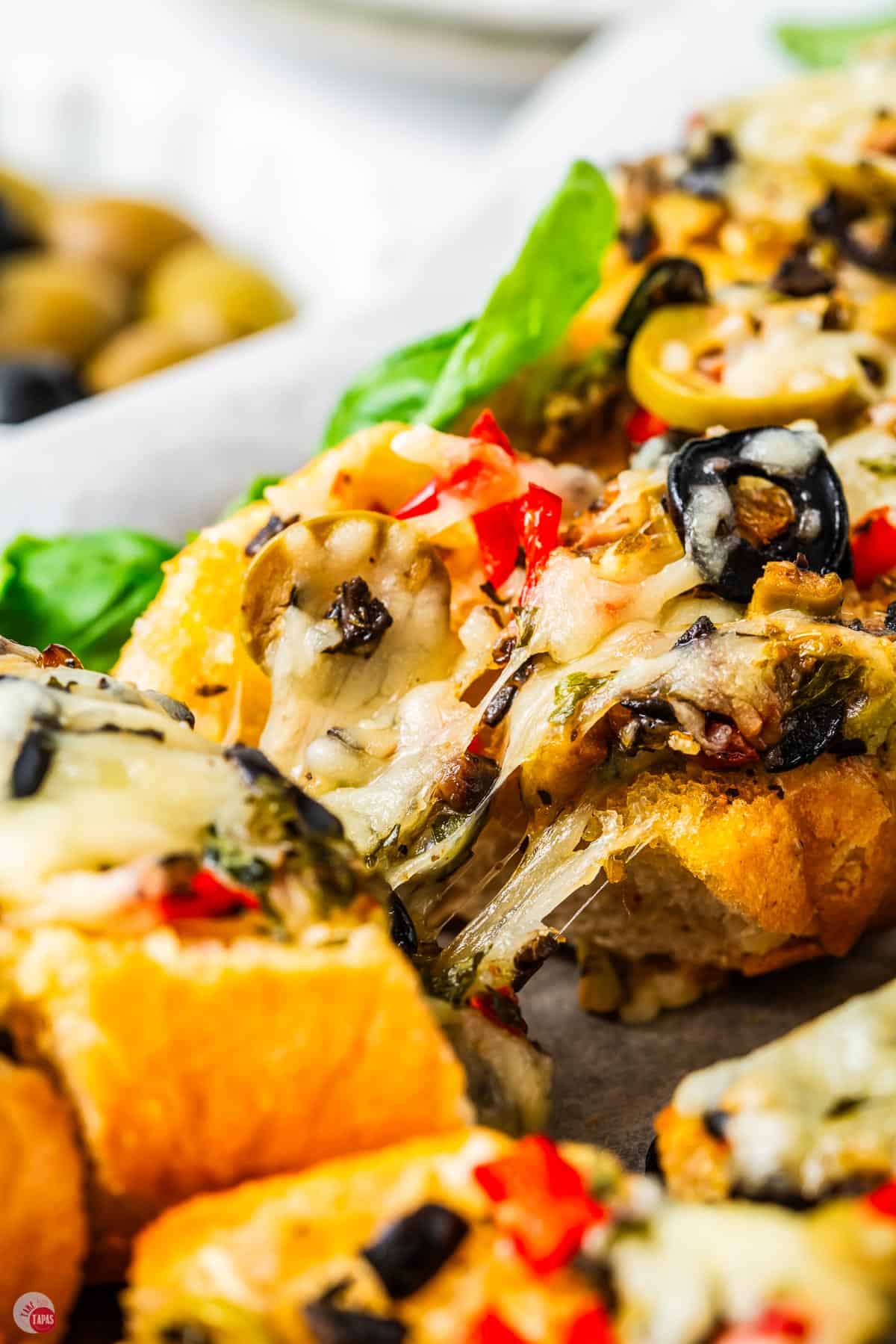 slices of cheesy olive bread on a plate