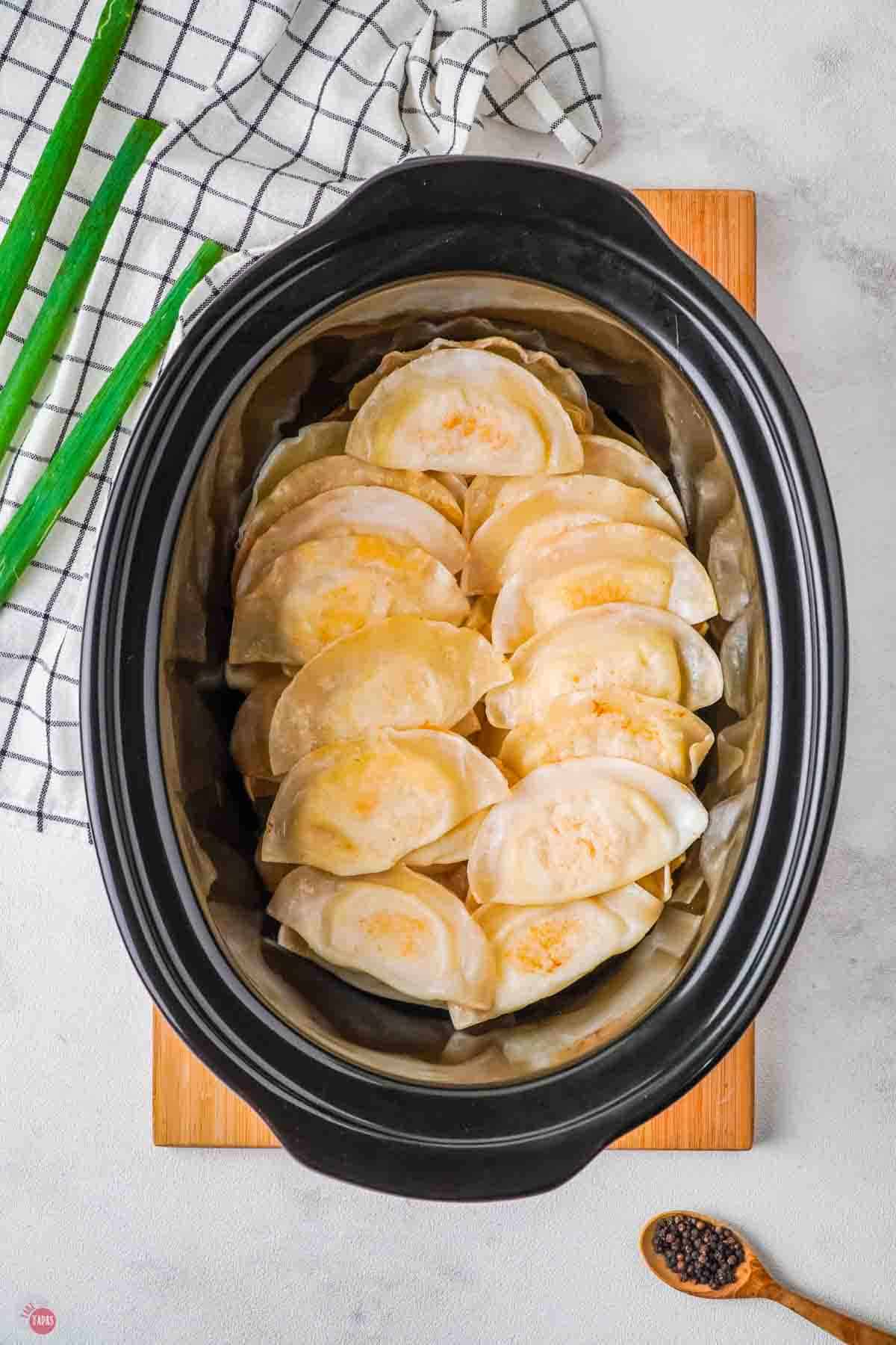 cheese pierogis in a black slow cooker