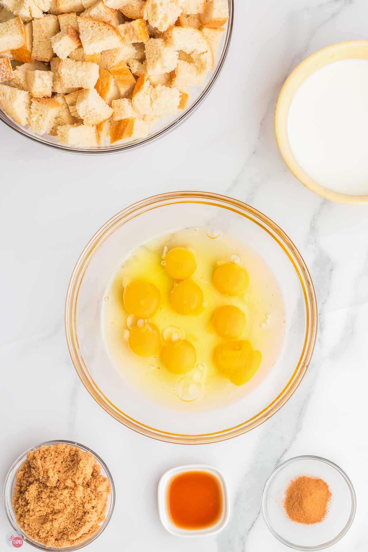 cracked eggs and milk in a clear bowl