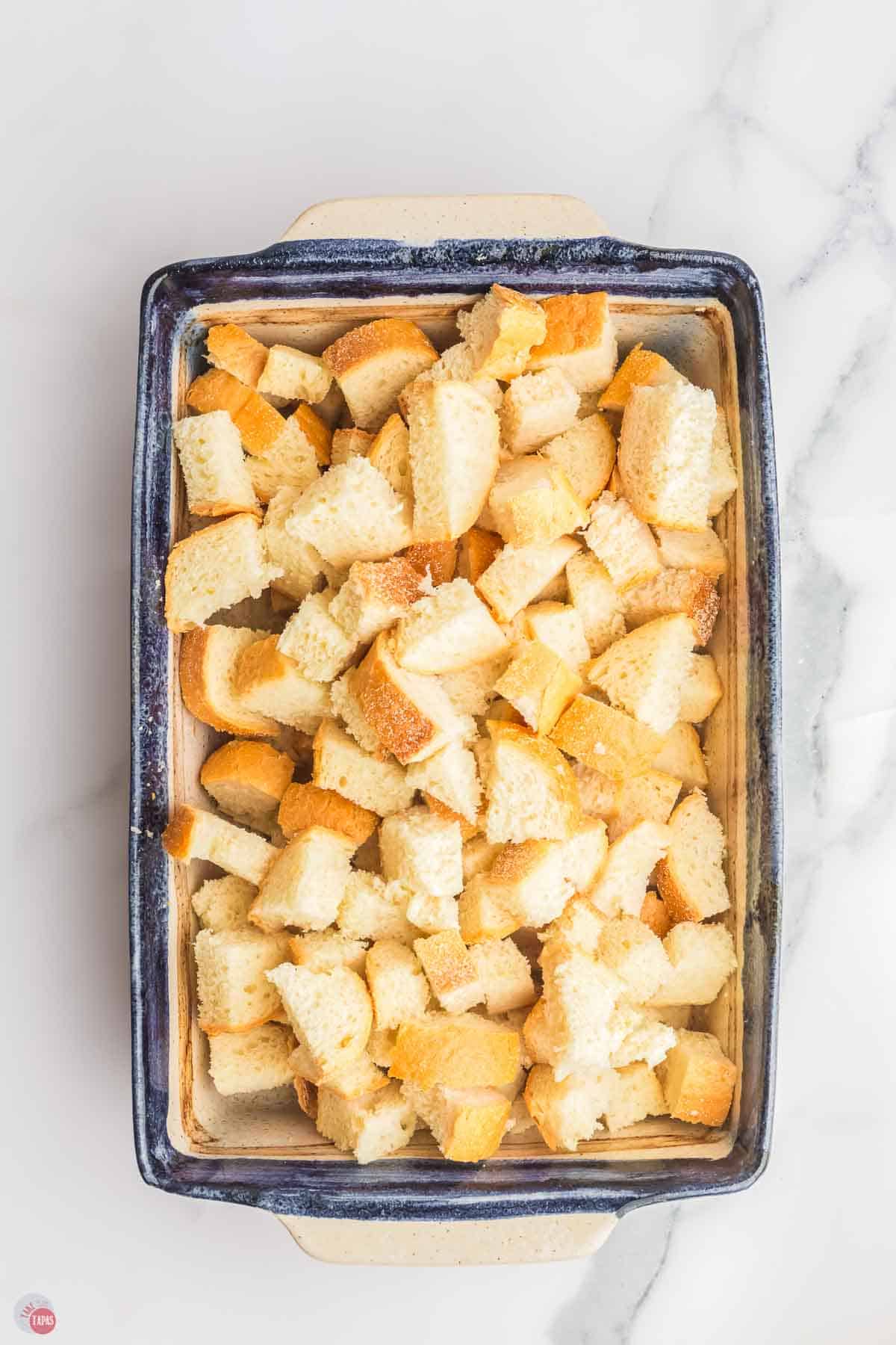 cubed french bread in a casserole dish