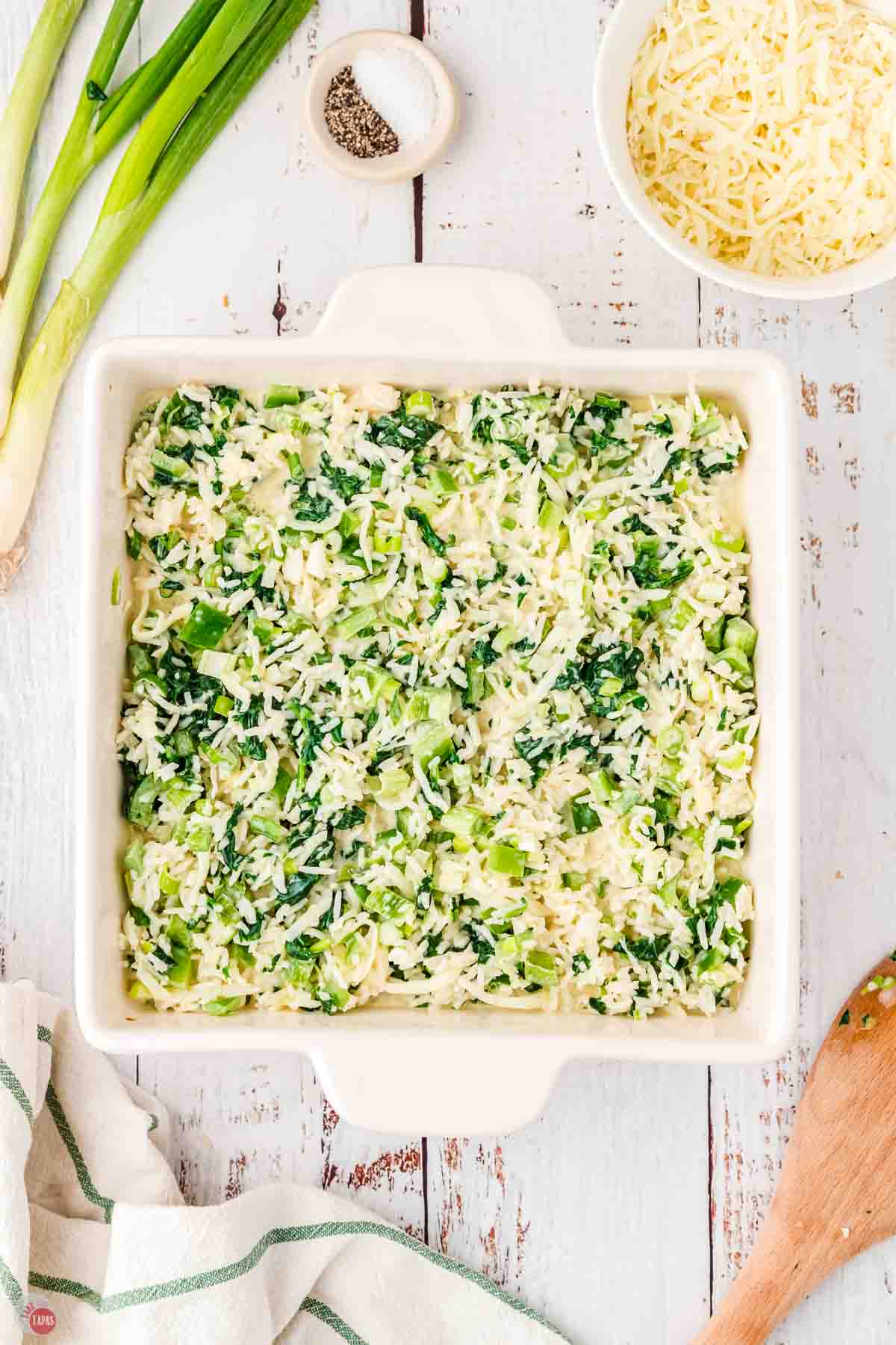 unbaked spinach casserole in a square white dish