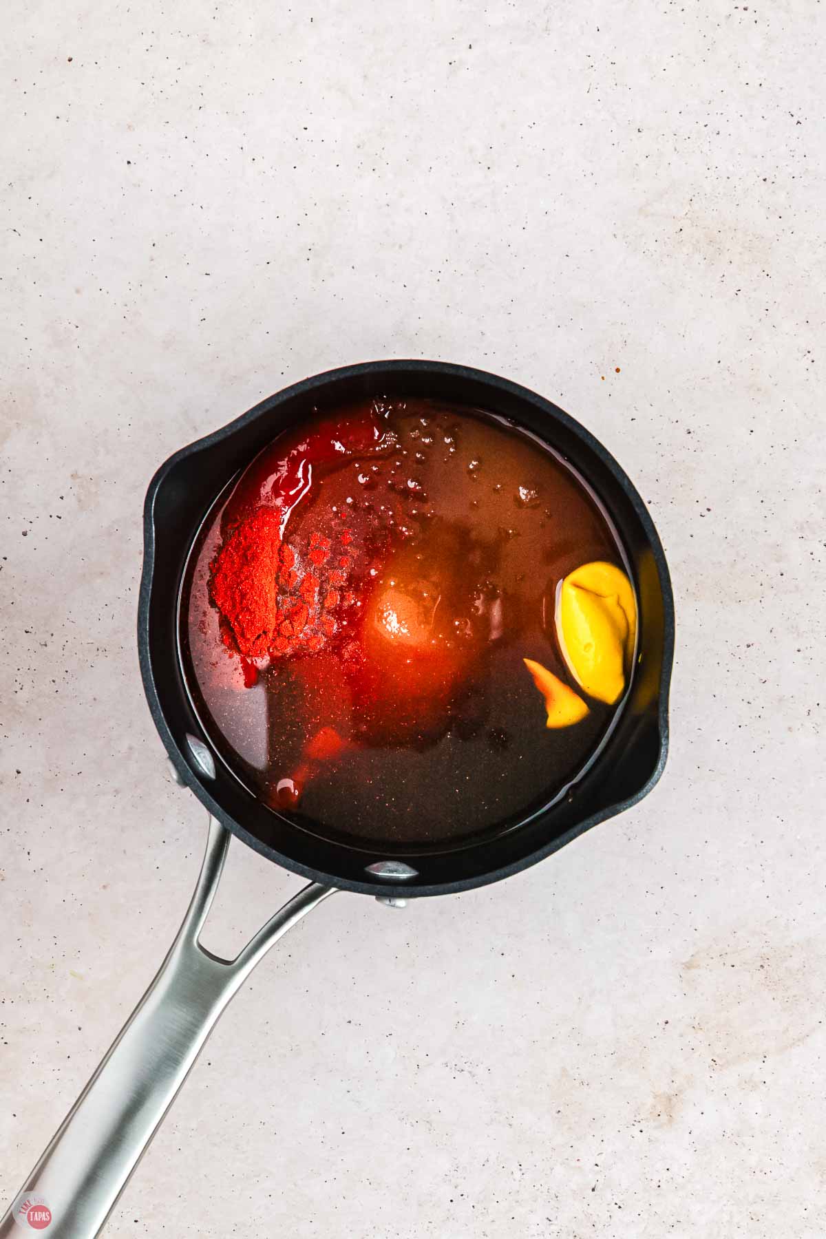 black pot with sauce ingredients in it before they stir them