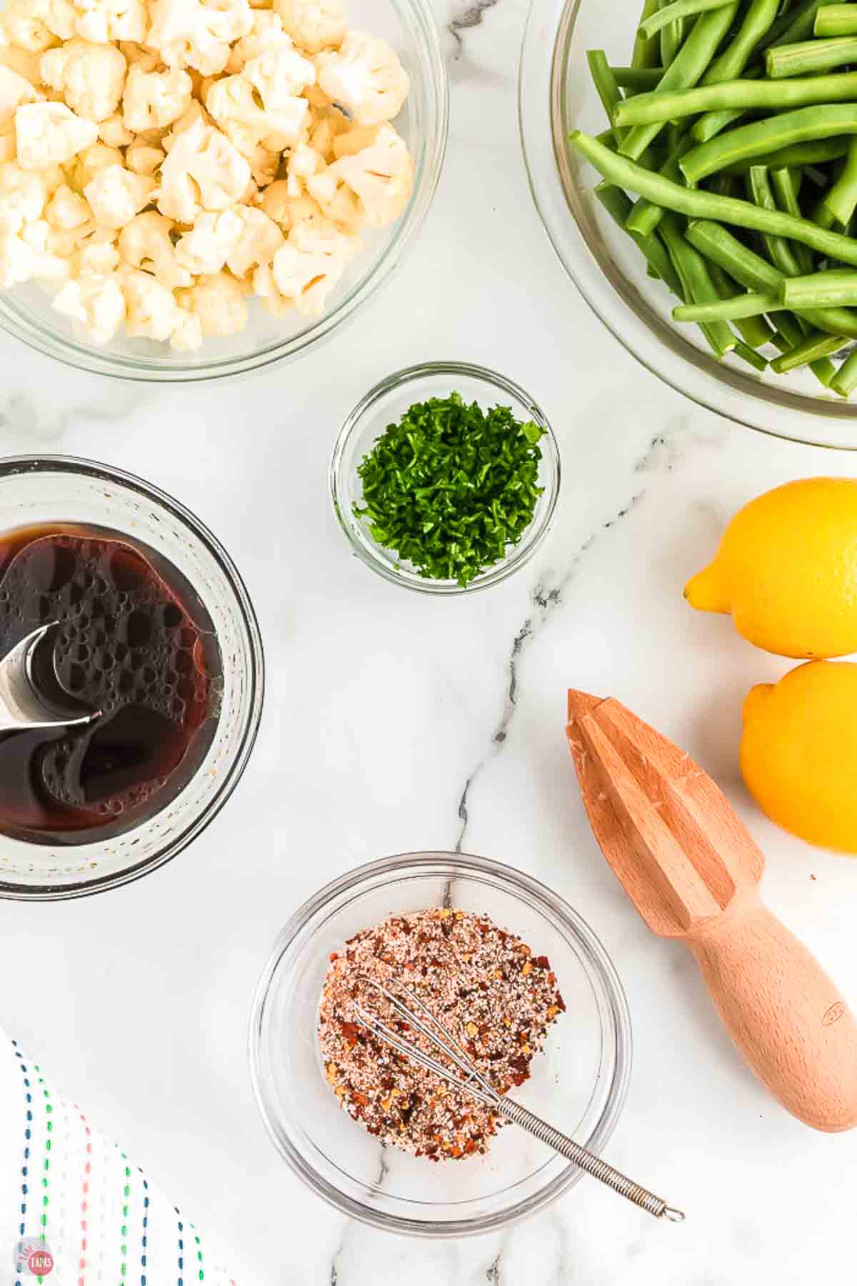 bowls of sauces and a bowl of spice mix next to lemons