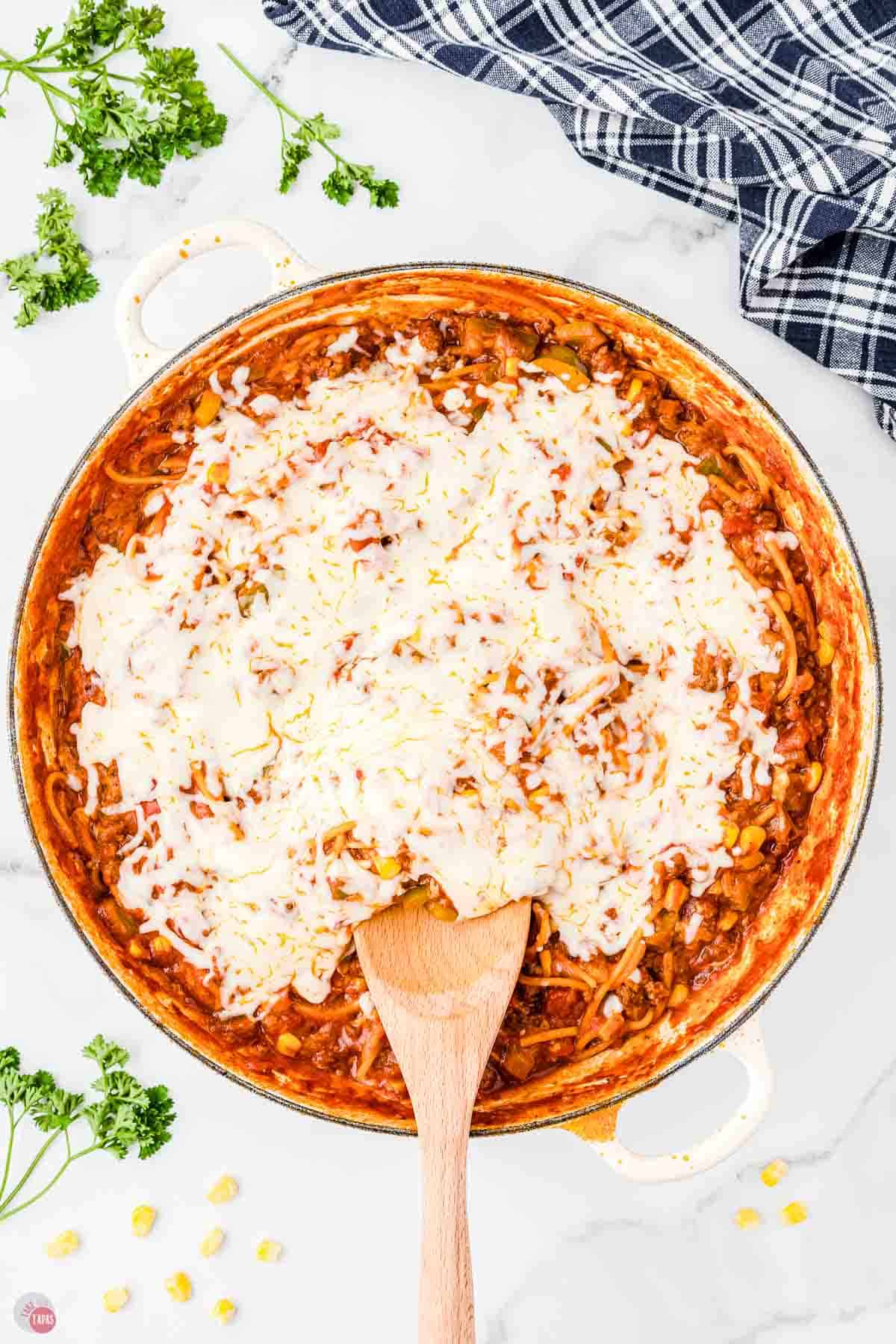 skillet with spaghetti, sauce, and melted cheese